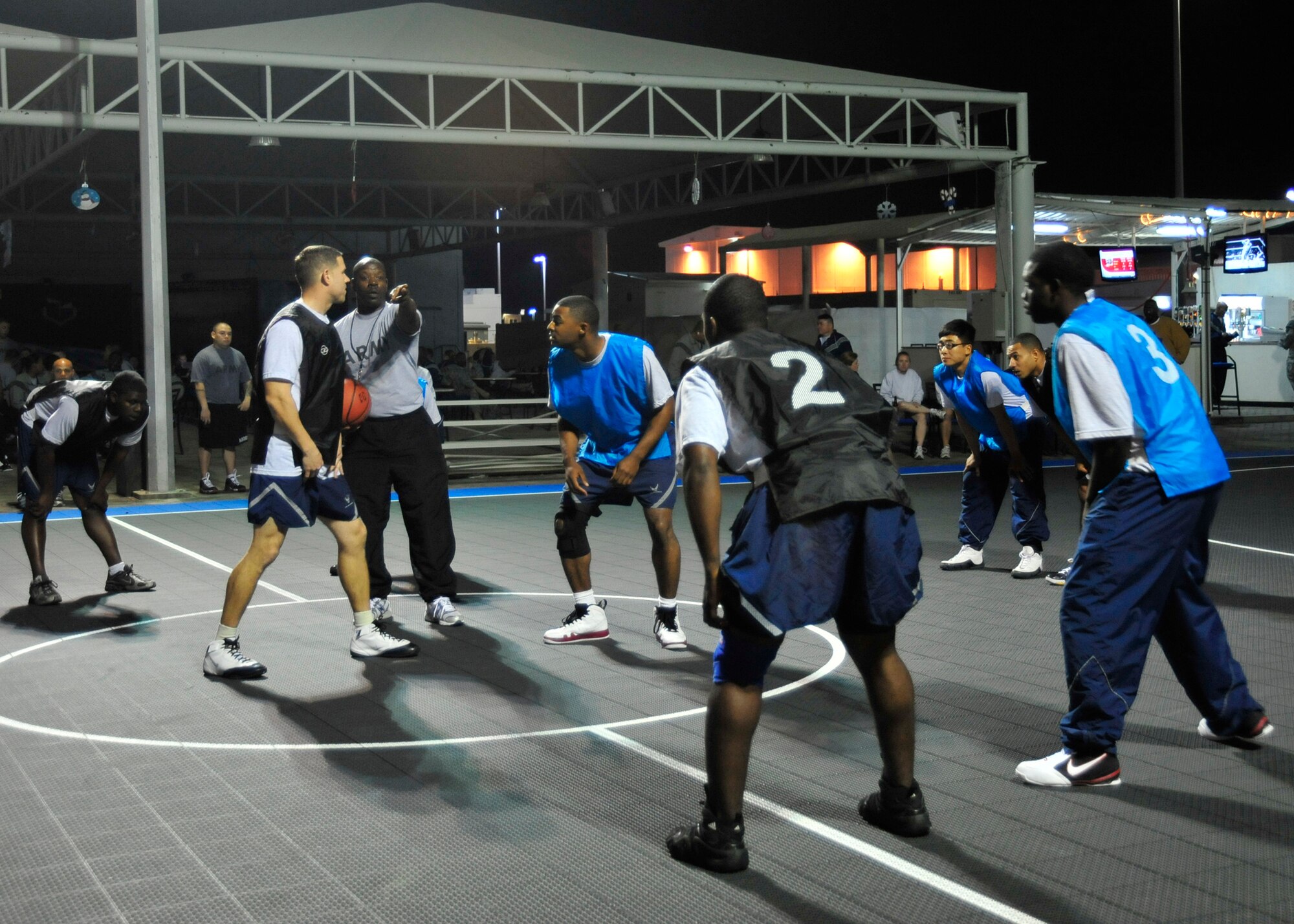 U.S. Army Sgt. 1st Class Samueal Hill referees the 380th Expeditionary Force Support Squadron team against the 380th Expeditionary Security Forces Squadron force protection team for the tip off during the 380th Expeditionary Force Support Squadron morale basketball tournament at an undisclosed location in Southwest Asia on Dec. 26, 2009. Force support sponsored the basketball tournament to increase morale within the base. (U.S. Air Force Photo/Senior Airman Jenifer H. Calhoun)
