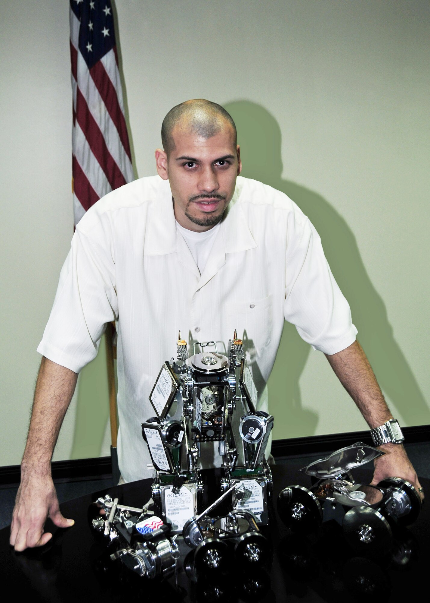 Miguel Rivera stands behind his sculptures he built from old hard drives and computer parts Dec. 19, 2009, at an air base in Southwest Asia. Mr. Rivera is a 386th Expeditionary Communications Squadron systems administrator. (U.S. Air Force photo/Tech. Sgt. Tony Tolley)