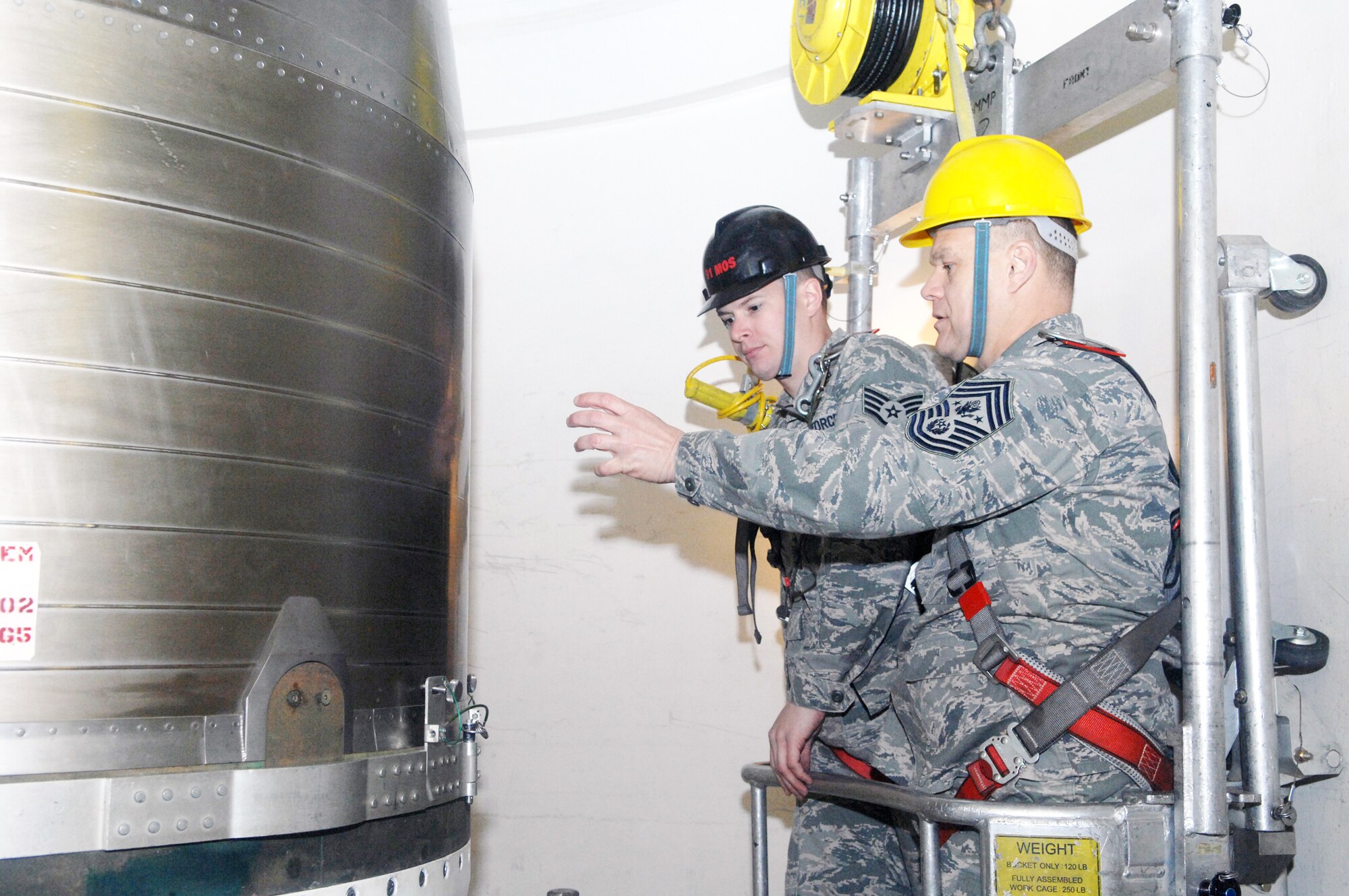Chief Master Sgt. of the Air Force James Roy (front) is given a cage ride in the missile maintenance trainer Dec. 24, 2009, by Staff Sgt. Chris Hawkins, a 91st Missile Maintenance Squadron missile maintenance instructor at Minot Air Force Base, N.D.  Chief Roy spent the Christmas holiday there and used the opportunity to meet Airmen from both the 5th Bomb Wing and the 91st Missile Wing and tell them their work in the nuclear enterprise is critical and that Air Force leaders are committed to their development.  (U.S. Air Force photo/Senior Airman Jesse Lopez)