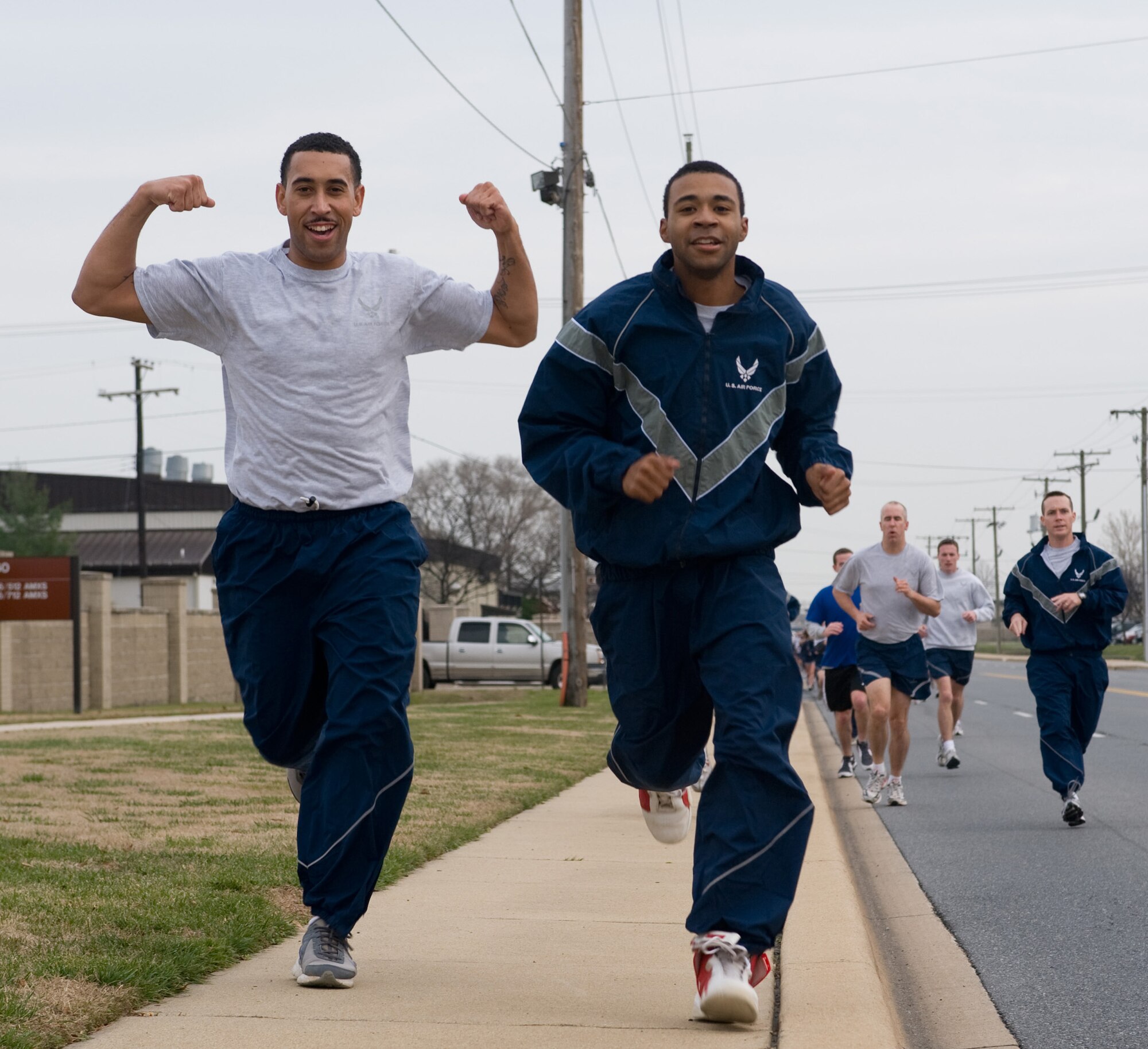(Left) Staff Sgt. Joshua Davis, 436th Force Support Squadron, strikes a pose as he runs beside Airman 1st Class Stephen Travagline, 436th FSS, during the Warrior Run Dec. 15. (U.S. Air Force photo/ Brianne Zimny)