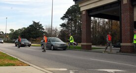 Maj. Gino Sarcomo, back left, Maj. James Blackman, front left, Chief Master Sgt. Mike Ivey, center, Chief Master Sgt. Terry Greene, second from right, and 1st Lt. Kendal Forrester, right, man the Dorchester Road main gate exit as members of Team Charleston head out for a holiday weekend Dec. 23. The Airmen manned the gate to encourage a safety-minded holiday for all. Chief Ivey is the 437th Airlift Wing command chief, Major Sarcomo is the 437th Communications Squadron commander, Major Blackman is the 437th Maintenance Operations Squadron commander, Chief Greene is the incoming 437 AW command chief and Lieutenant Forrester is an executive officer with the 437th Maintenance Group. (U.S. Air Force photo/Staff Sgt. Daniel Bowles)