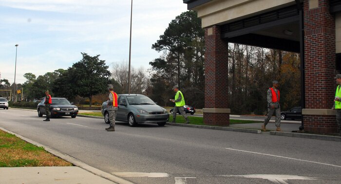 Maj. Gino Sarcomo, back left, Maj. James Blackman, front left, Chief Master Sgt. Mike Ivey, center, Chief Master Sgt. Terry Greene, second from right, and 1st Lt. Kendal Forrester, right, man the Dorchester Road main gate exit as members of Team Charleston head out for a holiday weekend Dec. 23. The Airmen manned the gate to encourage a safety-minded holiday for all. Chief Ivey is the 437th Airlift Wing command chief, Major Sarcomo is the 437th Communications Squadron commander, Major Blackman is the 437th Maintenance Operations Squadron commander, Chief Greene is the incoming 437 AW command chief and Lieutenant Forrester is an executive officer with the 437th Maintenance Group. (U.S. Air Force photo/Staff Sgt. Daniel Bowles)