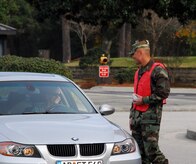 Maj. Gino Sarcomo greets a driver exiting Charleston AFB through the Dorchester Road main gate Dec. 23 during a holiday safety send-off. A total of 24 base agencies participated in the event, volunteering to man the Dorchester Road gate, the Rivers Avenue gate and the Gaylor Dining Facility for the safety sendoff to remind members of Team Charleston to put programs such as 0-0-1-3 into practice to while enjoying holiday festivities. Major Sarcomo is the 437th Communications Squadron commander. (U.S. Air Force photo/Staff Sgt. Daniel Bowles)
