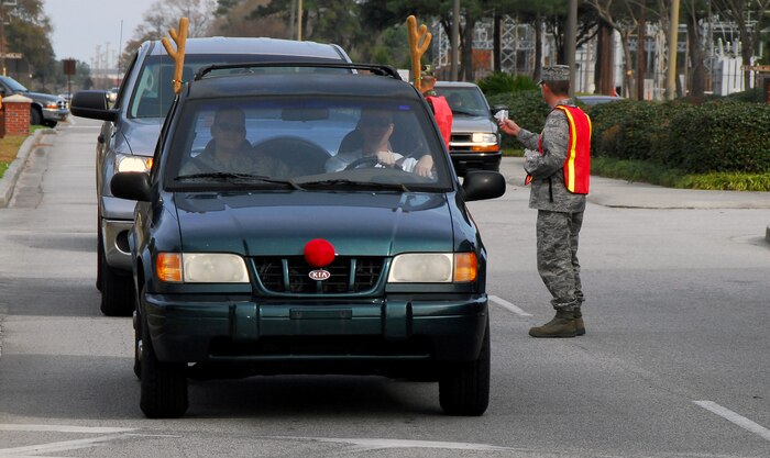 Charleston AFB Airmen exit the base through the Dorchester Road main gate here for the start of a four-day holiday weekend Dec. 23. The 437th Airlift Wing Safety Office hosted a safety send-off event at the Dorchester Road gate, Rivers Avenue gate and the Gaylor Dining Facility to stress the importance of safe driving habits and responsible alcohol use during holiday festivities. (U.S. Air Force photo/Staff Sgt. Daniel Bowles)