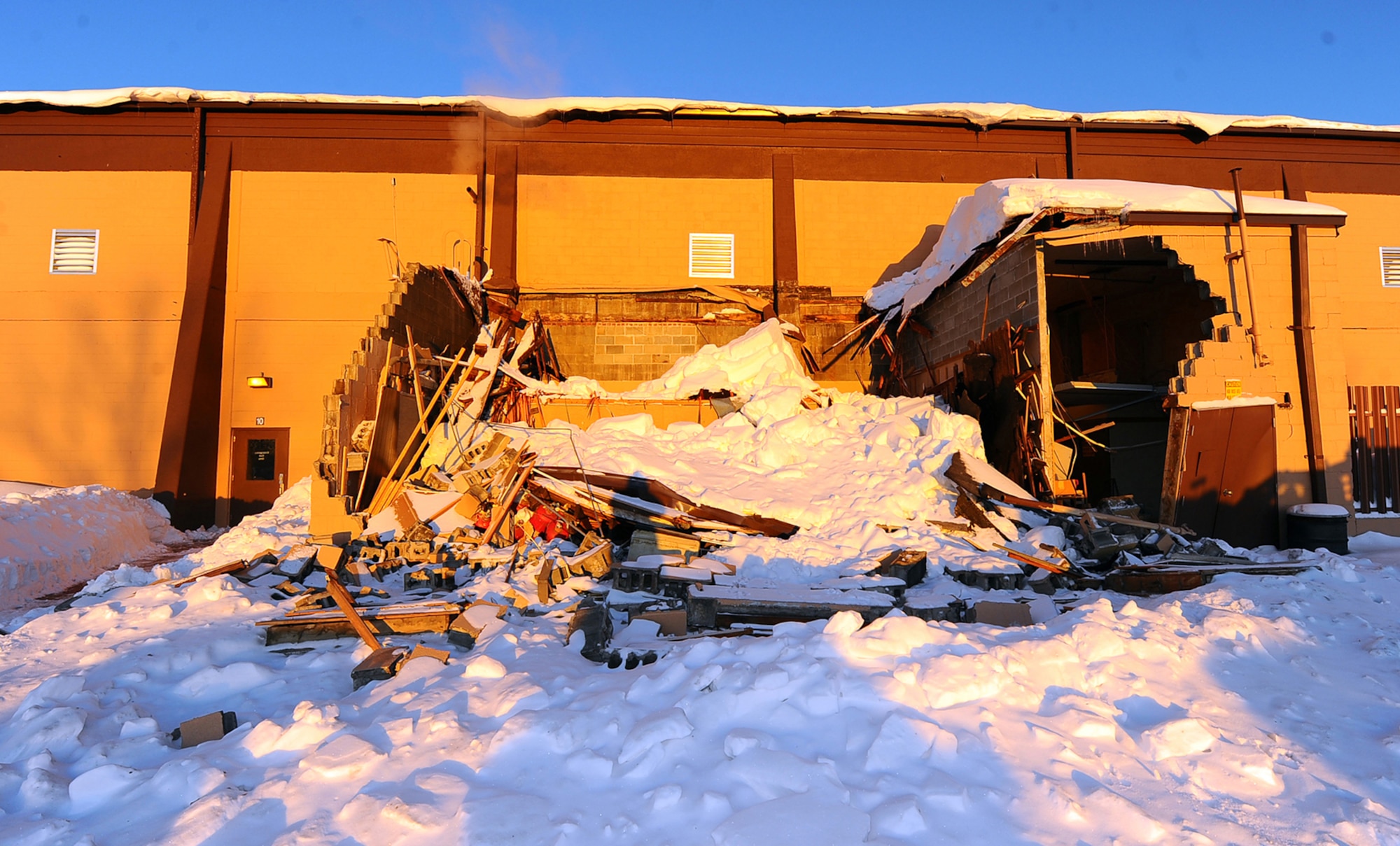 OFFUTT AIR FORCE BASE, Neb. - Accumulated snow collapses an outbuilding on the eastern annexes of the Offutt Field House Dec. 26. The base experienced two large snow storms in recent weeks that produced several feet of snow.  U.S. Air Force photo by Josh Plueger