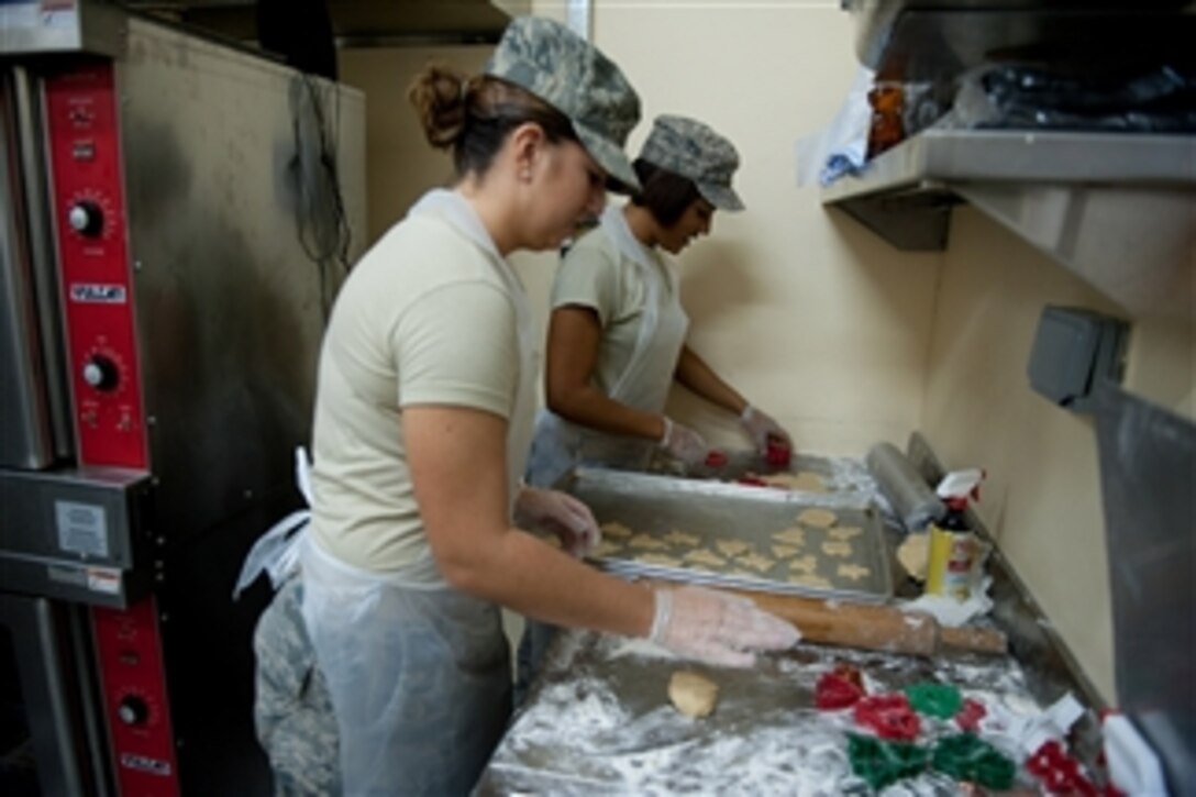 U.S. Air Force Airman 1st Class Molly Holzem (left) and Senior Airman Aja Blair, both with the 379th Expeditionary Force Support Squadron, prepare holiday cookies for service members at a location in southwest Asia on Dec. 23, 2009.  
