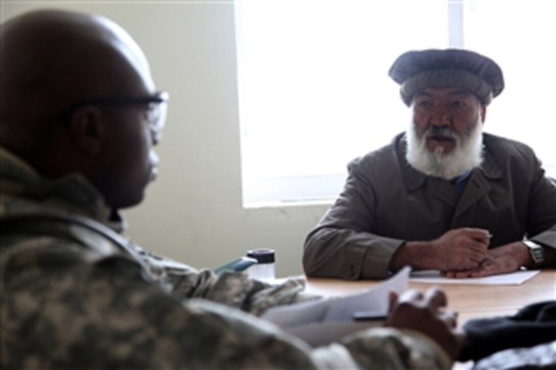 U.S. Army Capt. Booker Wilson, Company Commander of Bravo Company, 82nd Division Special Troops Battalion, talks with an Afghan elder during a key leader engagement in Parwan, Afghanistan, on Dec. 18, 2009.  