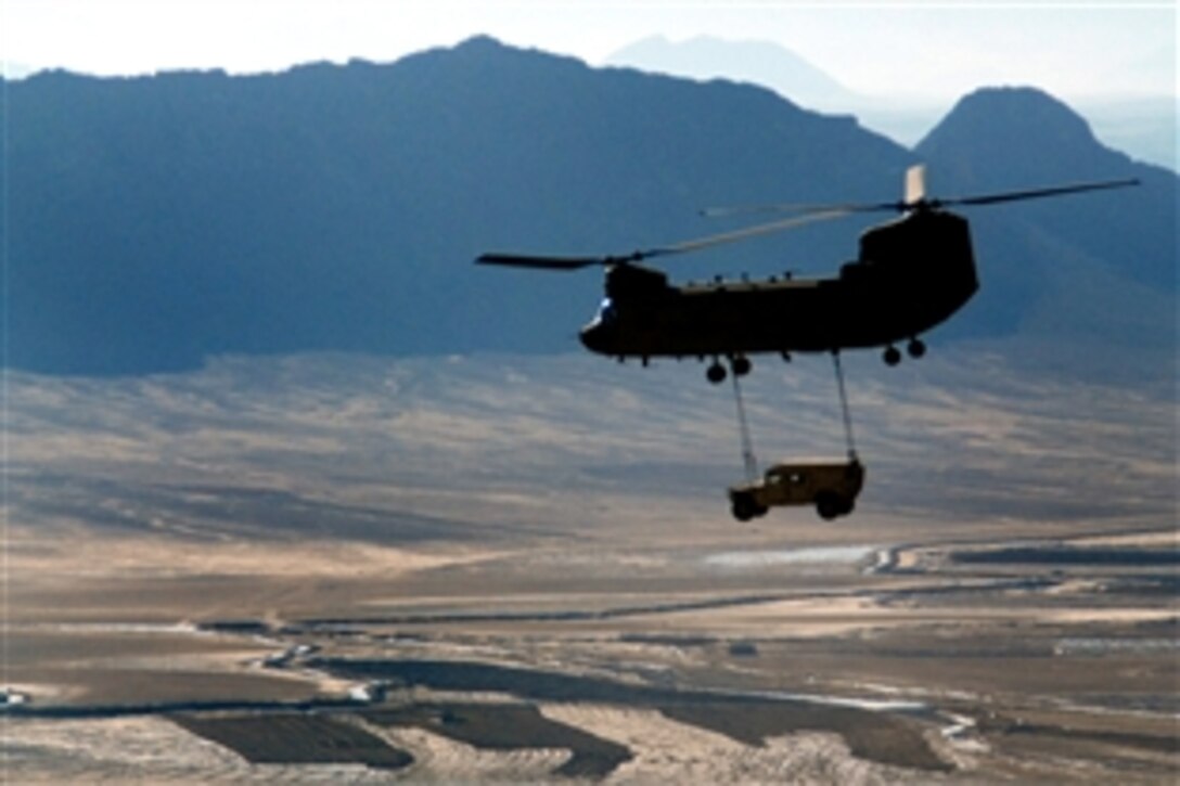 A U.S. Army CH-47F Chinook helicopter sling-loads a Humvee over Kandahar Province, Afghanistan, Dec. 25, 2009.