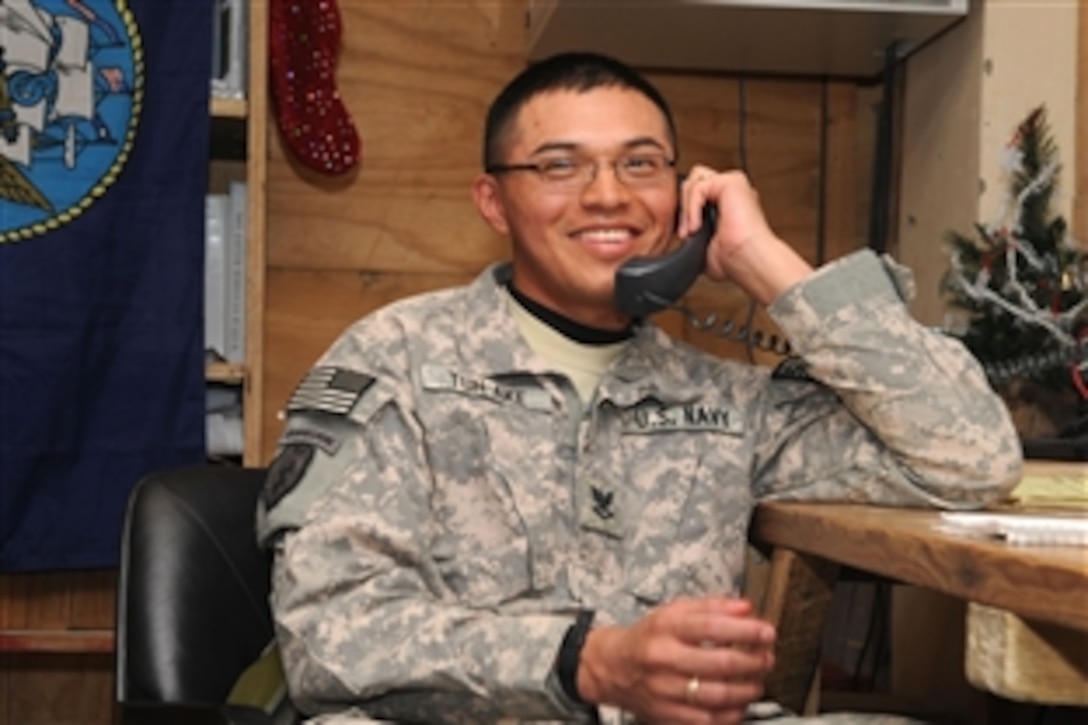 U.S. Navy Petty Officer 3rd Class Luis Tun-Ake receives a surprise Christmas Eve telephone call from President Barack Obama at Forward Operating Base Sharana, Afghanistan, Dec. 24, 2009. Tunake, from Denver, is serving with a Provincial Reconstruction Team in Paktika province.