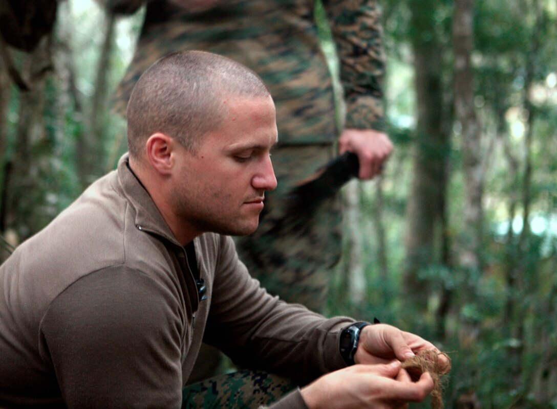 Cpl. Cody A. Cunningham, a reconnaissance man with Company C, 3rd Reconnaissance Battalion, 3rd Marine Division, III Marine Expeditionary Force, aids in creating a birds nest, pulled rope bound to resemble a birds nest, for the camp fire at the Jungle Warfare Training Center, Camp Gonsalves, Dec. 30.