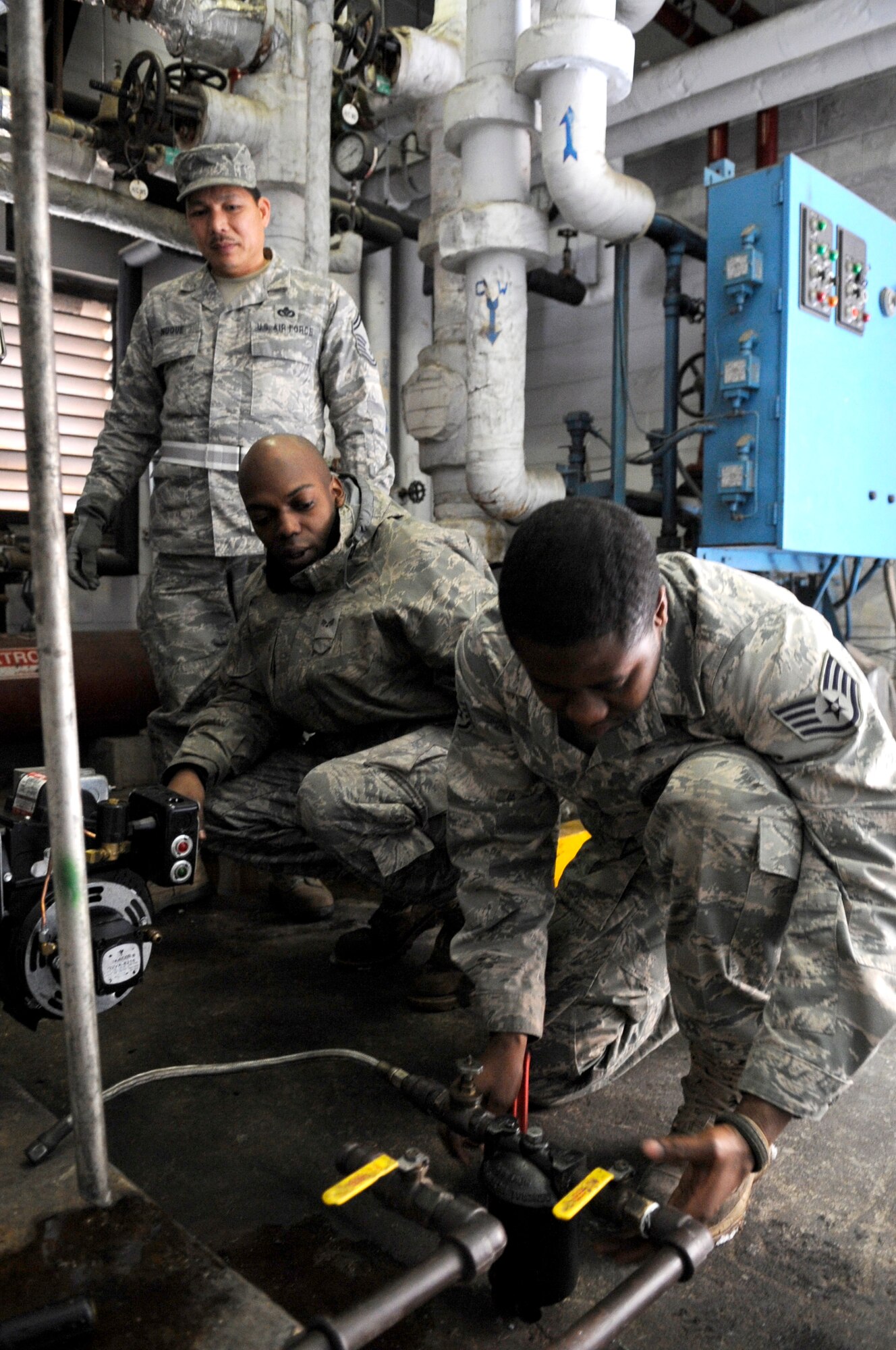 Senior Airman Luther Jackson (left) and Staff Sgt. Samuel Gedeon repair a boiler burner assembly in a building at Osan Air Base, Republic of Korea Dec. 29. Both airmen are heating ventilation and air conditioning technicians. ( U.S. Air Force photo/ Senior Airman Stephenie Wade)
