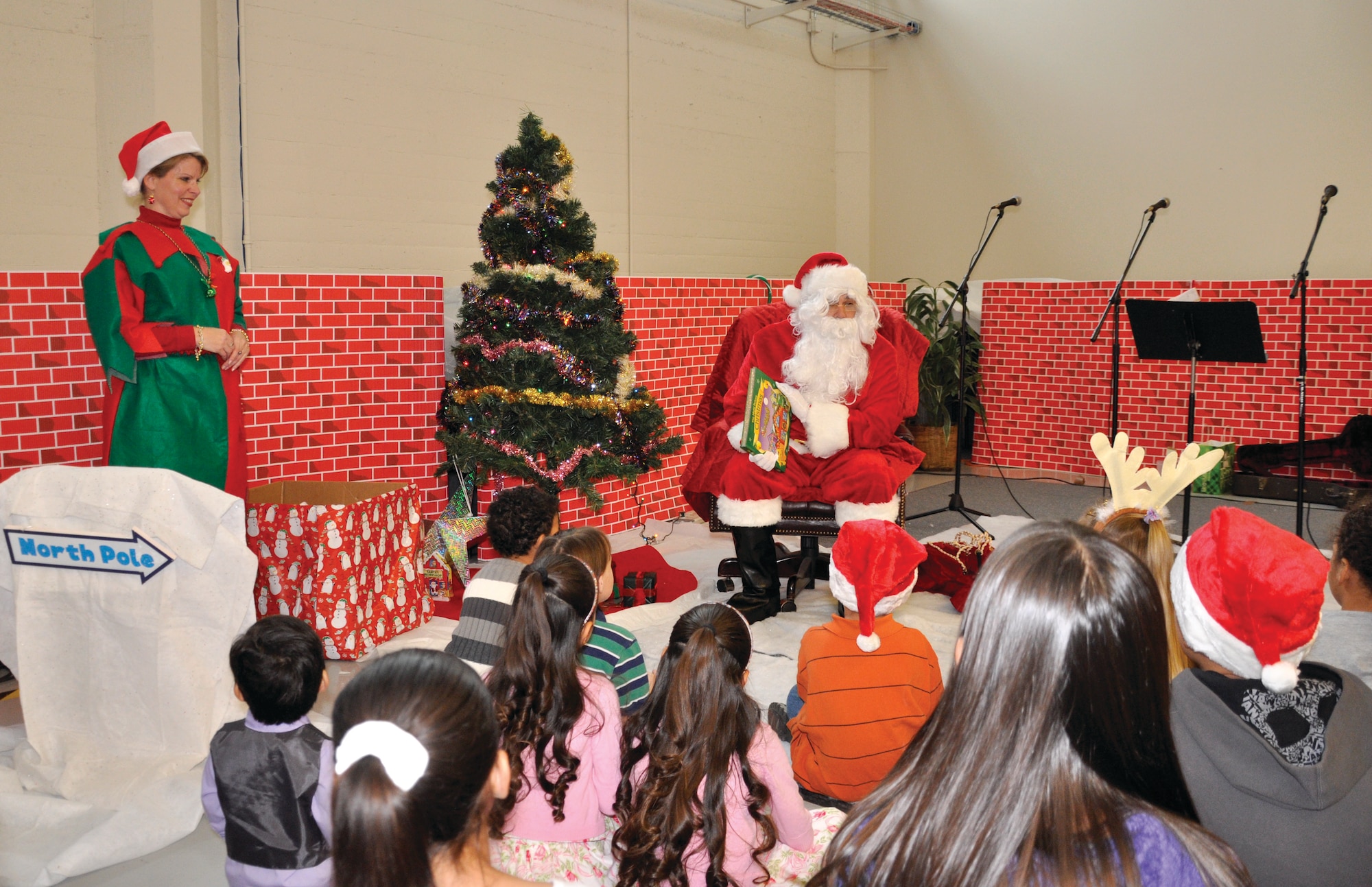 Santa Claus (Tech. Sgt. A.J. Lundgren) reads “‘Twas the Night Before Christmas to the children of the members of the 452nd Maintenance Group at their holiday party at March ARB. (U.S. Air Force photos by Tech. Sgt. Teresa Bertani)
