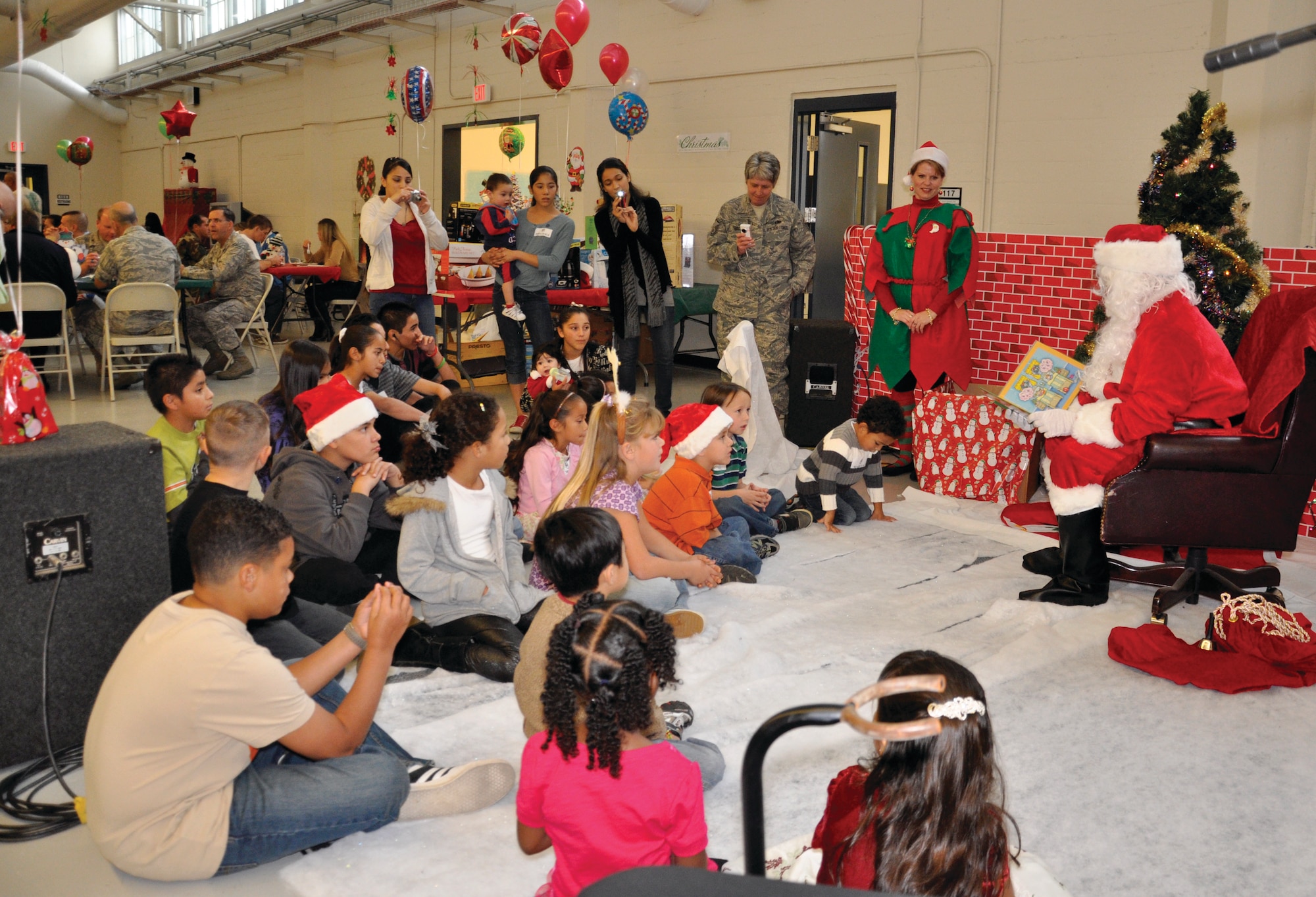 Santa Claus (Tech. Sgt. A.J. Lundgren) reads “‘Twas the Night Before Christmas to the children of the members of the 452nd Maintenance Group at their holiday party at March ARB. (U.S. Air Force photos by Tech. Sgt. Teresa Bertani)

