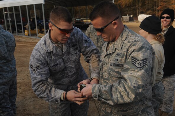 Airman 1st Class Bradley Taylor and Staff Sgt. Jason Luckenbaugh, 4th Civil Engineer Squadron explosive ordnance disposal technicians, prepare a high explosive charge on Seymour Johnson Air Force Base, N.C., Dec. 16, 2009. To prepare a charge, the Airmen tightly tape explosives together, focusing the effects of a detonation. (U.S. Air Force photo/Senior Airman Ciara Wymbs)