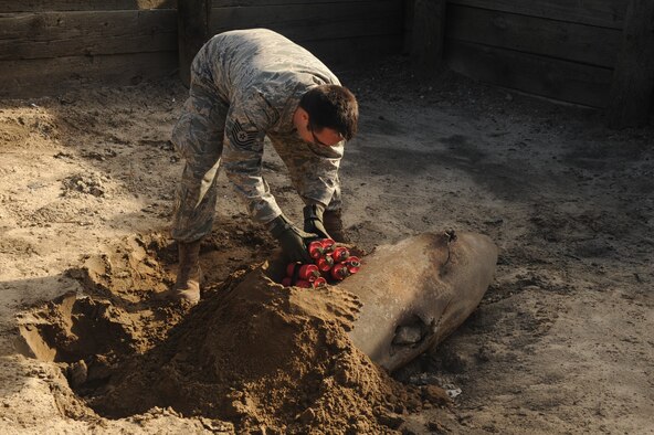 Tech. Sgt. Cecil McCrackin, 4th Civil Engineer Squadron explosive ordnance disposal technician, shows proper placement of incendiary charges on an inert piece of ordnance at Seymour Johnson Air Force Base, N.C., Dec. 16, 2009. Proper placement ensures a piece of ordnance does not move from the spot during detonation. (U.S. Air Force photo/Senior Airman Ciara Wymbs)