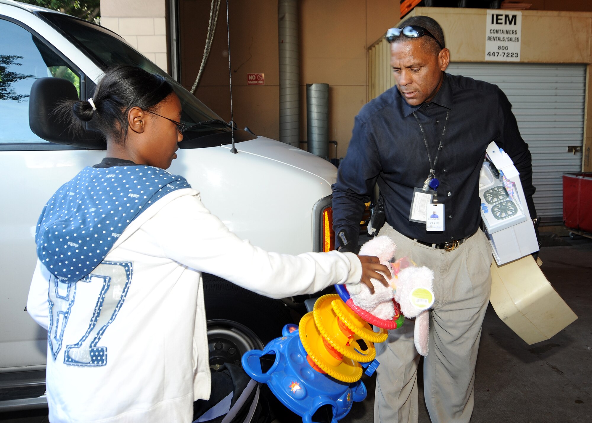 Maria Simmons hands a toy to a staff member at the Union Rescue Mission, Los Angeles, Dec. 18.  Maria and other members from the Los Angeles Air Force Base Youth Programs delivered a van full of toys, clothing and other items collected through donations from the base’s Airman & Family Readiness Center, the Airmen’s Attic and several families on base. The event was part of YP’s Community Out Reach Program, which teaches youths the importance of humanity and caring for others. (Photo by Joe Juarez)