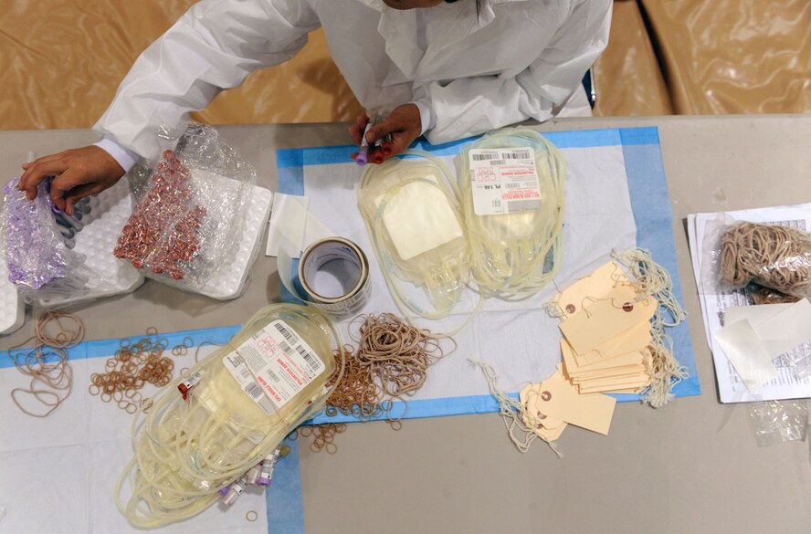 MOODY AIR FORCE BASE, Ga. -- Priscilla Gaona, American Red Cross collection technician two, prepares vials, blood bags and tag labels during a blood drive here Dec. 22. Donated blood is divided into three different categories; plasma, platelets and red cells, each of which is provided during the donation process, supporting the idea that each person who donates blood could potentially save three lives. (U.S. Air Force photo by Airman 1st Class Joshua Green)