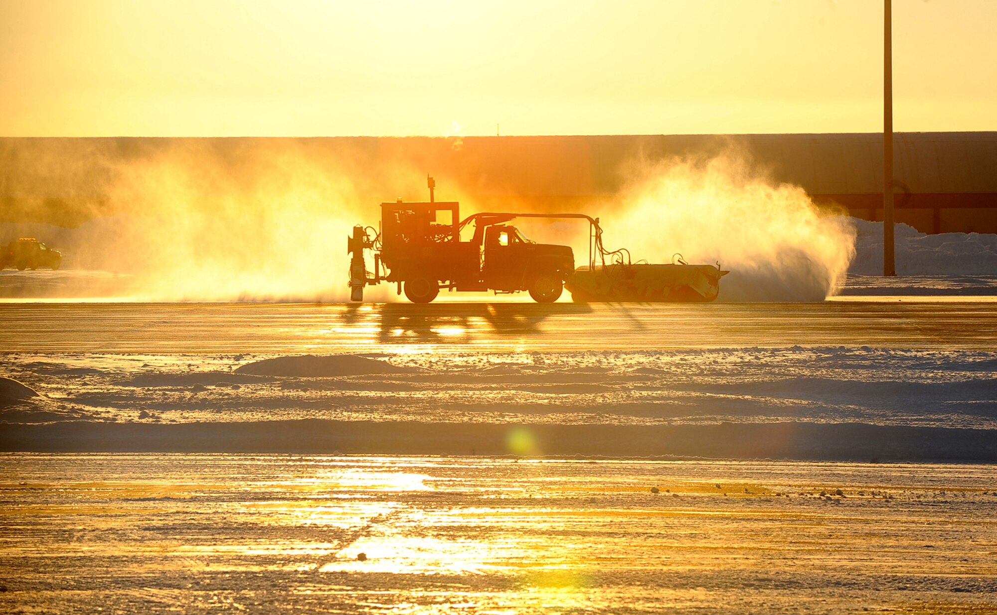 OFFUTT AIR FORCE BASE, Neb. - A 55th Civil Engineer Squadron snow brush driver clears a ramp here Dec. 28.  Offutt's snow removal crews have been working around the clock to ensure the operational integrity of the Offutt flight line and off ramps after the Omaha metro area was blanketed in several feet of snow during two recent snow storms.  U.S. Air Force photo by Josh Plueger