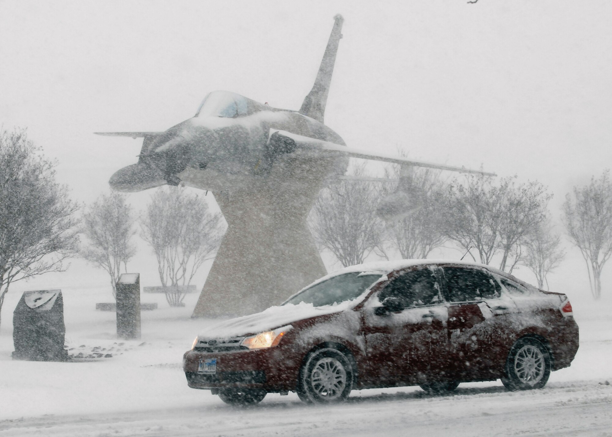 A motorist on Sheppard Air Force Base, Texas, takes is slow Dec. 24 as a heavy snow falls across the region. More than 10 inches of snow fell in the area, causing blizzard-like conditions. (U.S. Air Force photo/Harry Tonemah)