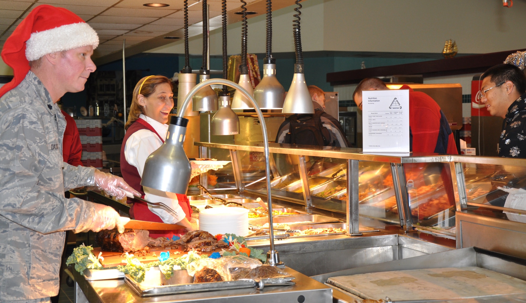 Lt. Col. Drew Daugherty, 82nd Mission Support Group deputy commander serves Christmas meals to Airmen Dec. 25. Officers manned the food stations at the Tumbleweed Dining Facility during this year’s event. (U.S. Air Force Photo/ Airman 1st Class Adawn Kelsey)