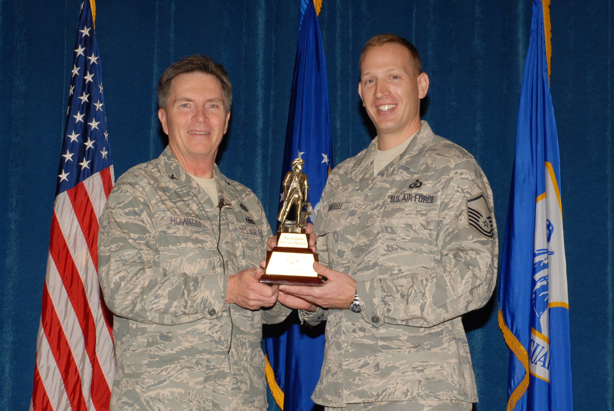 McGHEE TYSON AIR NATIONAL GUARD BASE, Tenn. -- Master Sgt. Herbert J. Harrell, right, an enlisted professional military education instructor, receives the meritorious service award from Col. Richard B. Howard, commander, upon his departure from assignment at The I.G. Brown Air National Guard Training and Education Center here, Dec. 18, 2009. (U.S. Air Force photograph by Master Sgt. Mavi Smith/Released)