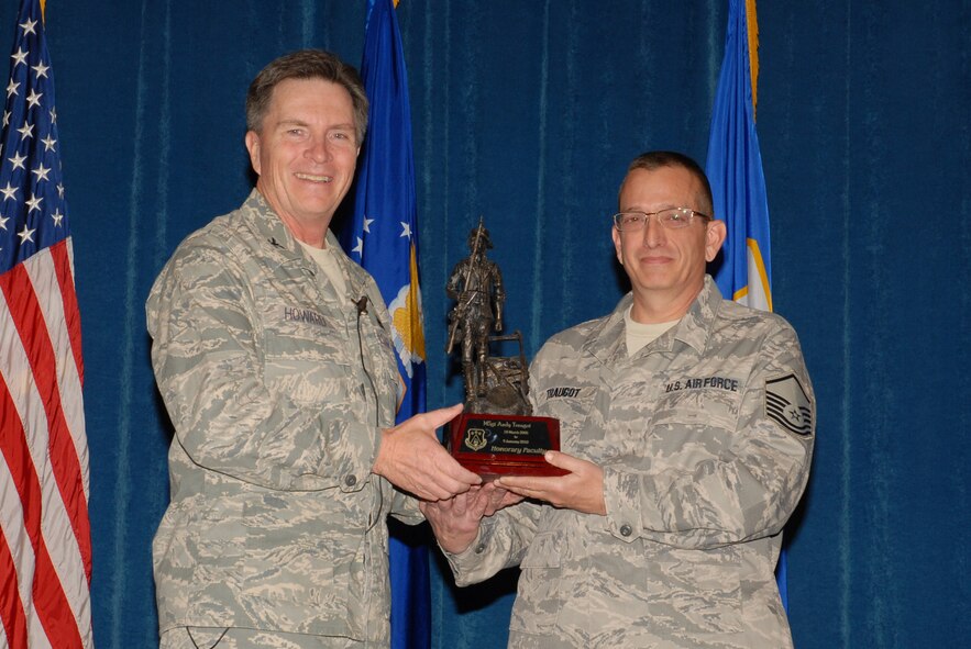 McGHEE TYSON AIR NATIONAL GUARD BASE, Tenn. -- Master Sgt. Andrew D. Traugot, right, an instructional systems analyst for the enlisted professional military education branch, receives the honorary faculty award from Col. Richard B. Howard, commander, upon his departure from assignment at The I.G. Brown Air National Guard Training and Education Center here, Dec. 18, 2009.  (U.S. Air Force photograph by Master Sgt. Mavi Smith/Released)