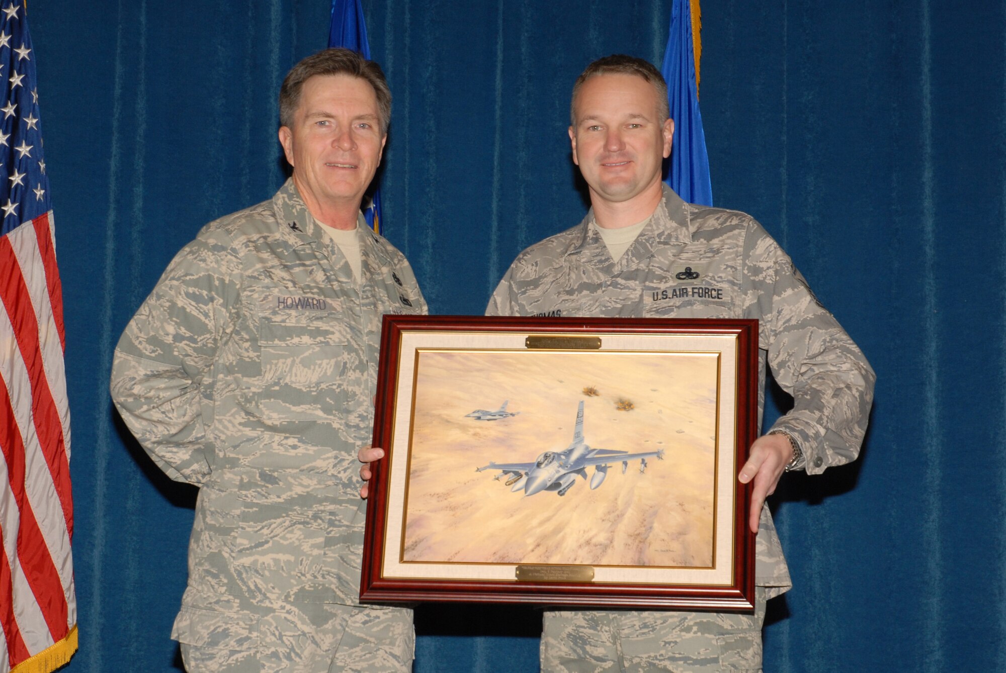 McGHEE TYSON AIR NATIONAL GUARD BASE, Tenn. -- Senior Master Sgt. Kevin Thomas, right, the director of resources for enlisted professional military education, receives a heritage painting from Col. Richard B. Howard, commander, upon his departure from assignment at The I.G. Brown Air National Guard Training and Education Center here, Dec. 18, 2009.  (U.S. Air Force photograph by Master Sgt. Mavi Smith/Released)