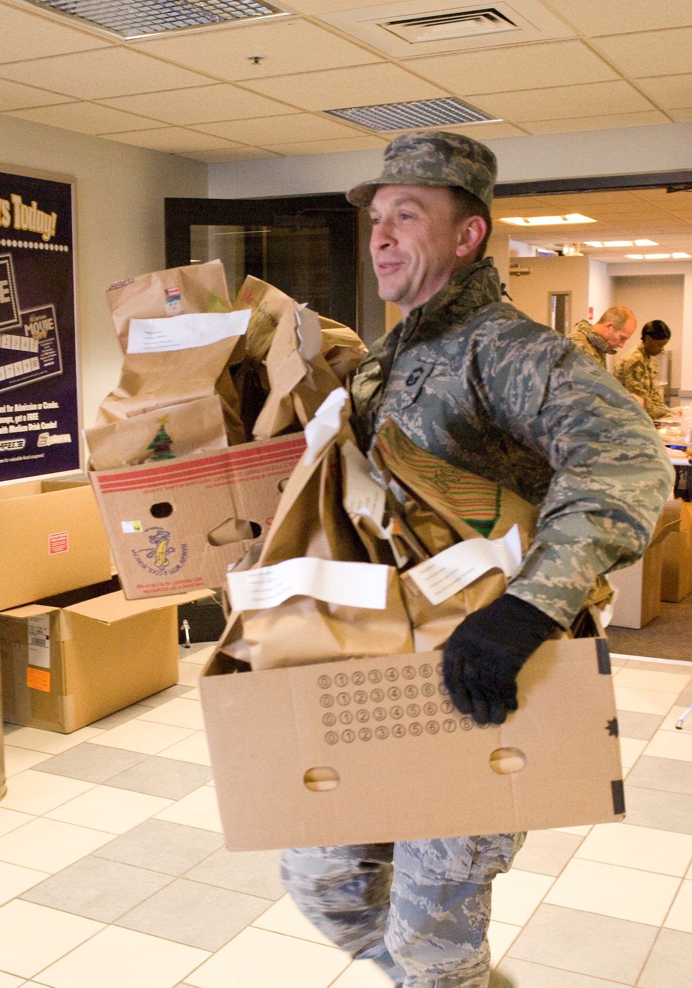 Chief Master Sgt. (select) Albert Christman, 736th Aircraft Maintenance Squadron, carries boxes overflowing with packages of cookies Dec. 23 for Operation Cookie Drop, an annual event sponsored by the Dover Chiefs Group, as a way to spread holiday cheer. (U.S. Air Force photo/ Brianne Zimny)
