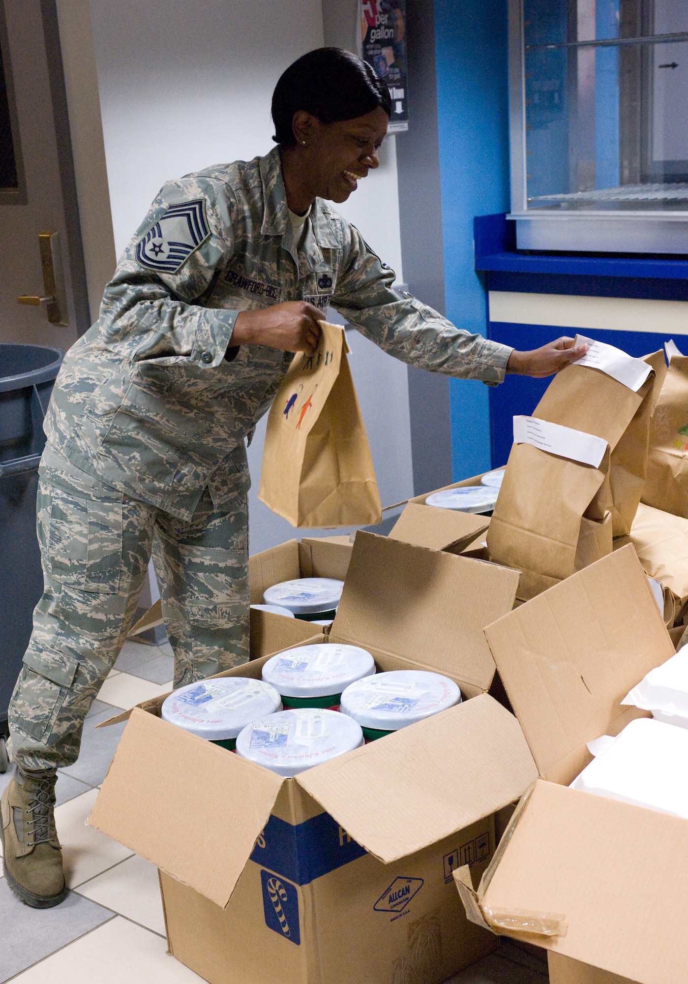 Chief Master Sgt. Cassandra Crawford-Bice, 436th Mission Support Group superintendent, helps organize packages and boxes of cookies for Operation Cookie Drop Dec. 23 at the Base Theater. (U.S. Air Force photo/Brianne Zimny)