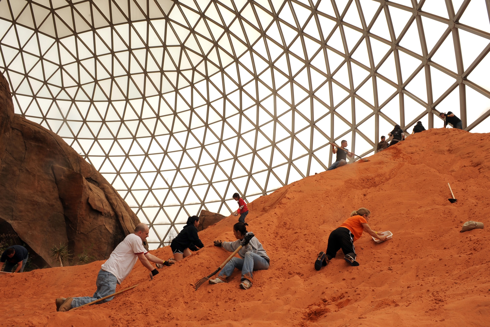 OFFUTT AIR FORCE BASE, Neb. - Servicemembers clean sand dunes inside the Henry Doory Zoo?s Desert Dome as part of Offutt?s annual Zoo Clean-Up event April 18. For many years, Team Offutt volunteers have helped prepare the zoo for its busiest season. U.S. Air Force photo by Josh Plueger