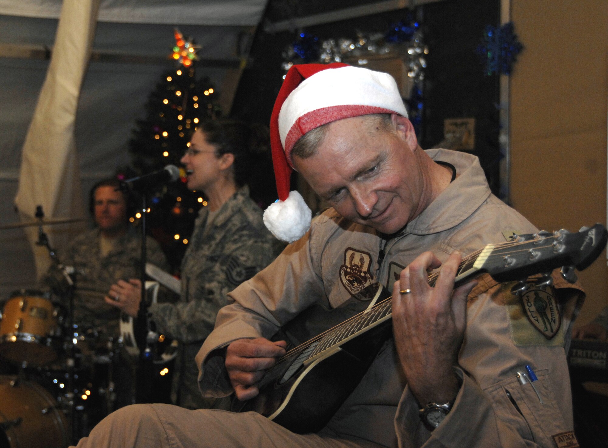 KANDAHAR AIRFIELD, Afghanistan -- Brig. Gen. Guy M. Walsh, 451st Air Expeditionary Wing commander, strums a few notes at the 451st Air Expeditionary Wing holiday party with the U.S. Air Forces Central Command Band “Sirocco” Dec. 24. The band is deployed to Southwest Asia from Lackland Air Force Base, Texas. (U.S. Air Force photo/Capt. Kristen D. Duncan)
