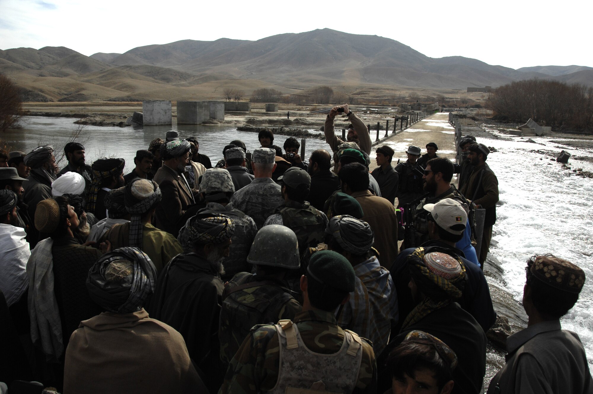 ZABUL PROVINCE, Afghanistan -- A crowd of U.S. military servicemembers and Afghans gather for the Arghandab Bridge opening ceremony Dec. 26.  This bridge is approximately 200 meters long, four meters wide and has a high load-bearing capacity.  Although simple, this bridge allows easy maintenance for the Afghans.  Maj. Gen. Stephen Mueller, U.S. Air Forces Central Air Component Coordination Element director, Brig. Gen. Frederick Hodges, director of operations for Regional Command South, Brig. Gen. Guy Walsh, 451st Air Expeditionary Wing commander and Zabul’s Provincial Governor Mohammad Ashraf Naseri were some of the top officials in attendance. (U.S. Air Force photo/Senior Airman Timothy Taylor)     