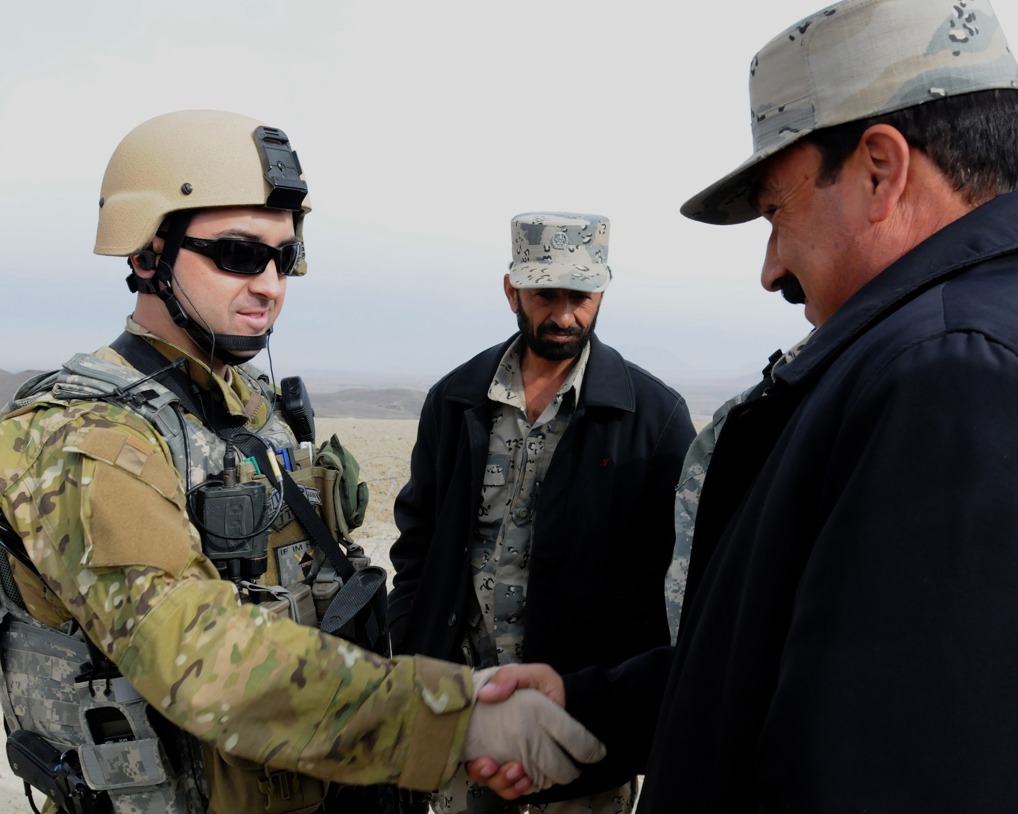 U.S. Air Force Capt. Roger M. Brooks IV, from Marietta, Ga., commander of a twelve-man Joint Terminal Attack Controllers team, extends a hand of support to Col. Niazy, Afghan border police commanding officer, 6th Kandak, 201st Corps, at an ABP observation post in the mountains of the Achin District of eastern Afghanistan's Nangarhar province, Dec. 20. (U.S. Army Photo/Sgt.  Tracy Smith)