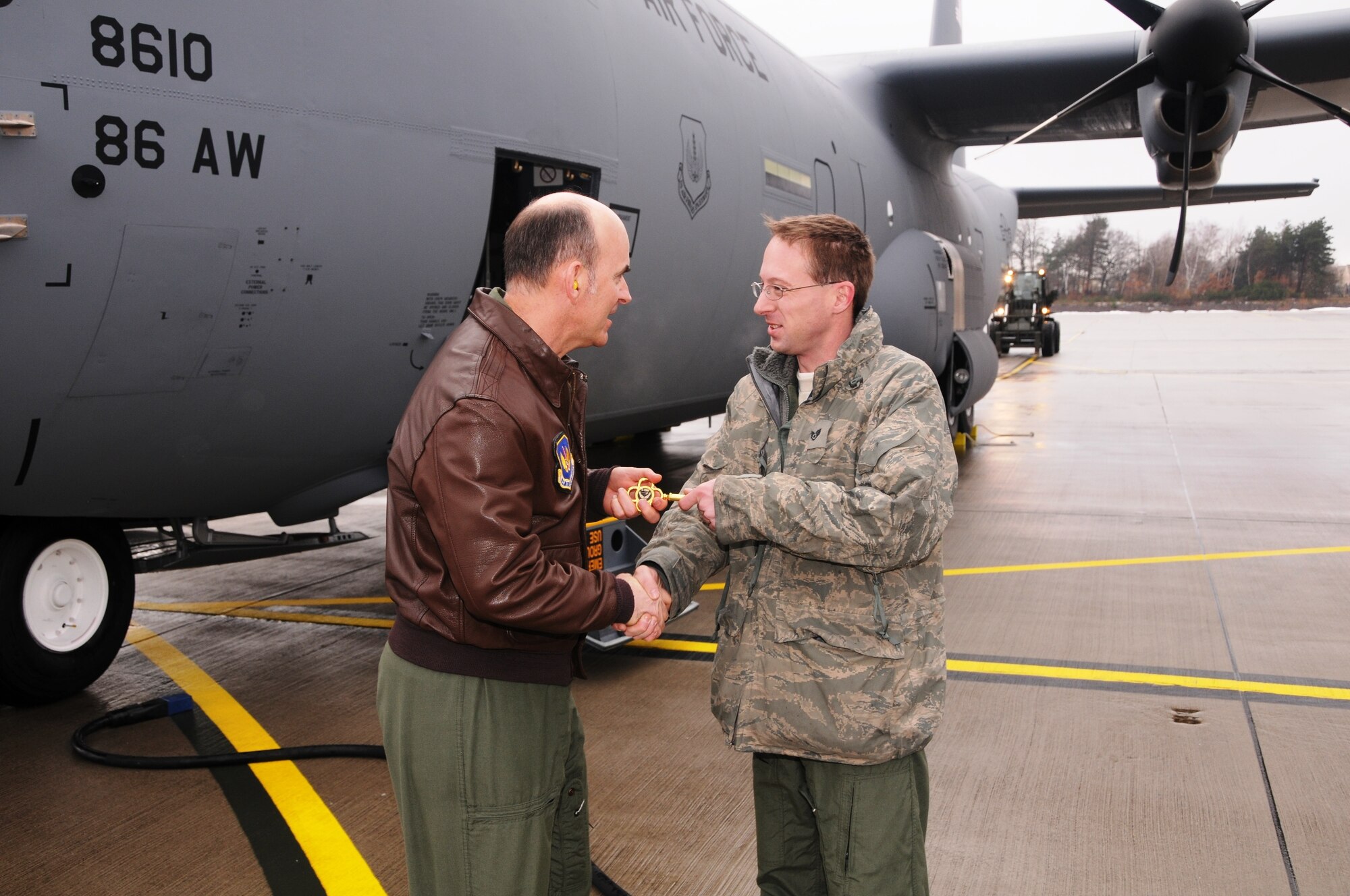 RAMSTEIN AIR BASE, Germany -- 17th Air Force Vice Commander Brig. Gen. Michael Callan hands the ceremonial key to a new C-130J Super Hercules aircraft to 86th Aircraft Maintenance Squadron crew chief Staff Sgt. Jason Keithley after landing the aircraft here Dec. 23. The J-model, one of two aircraft delivered to the 37th Airlift Squadron on the day, gives the unit a total of 10 J-models received. General Callan was latest in a series of Ramstein senior leaders selected to fly the new aircraft back from the Lockheed-Martin plant in Marietta, Ga. (U.S. Air Force photo by Master Sgt. Jim Fisher)
