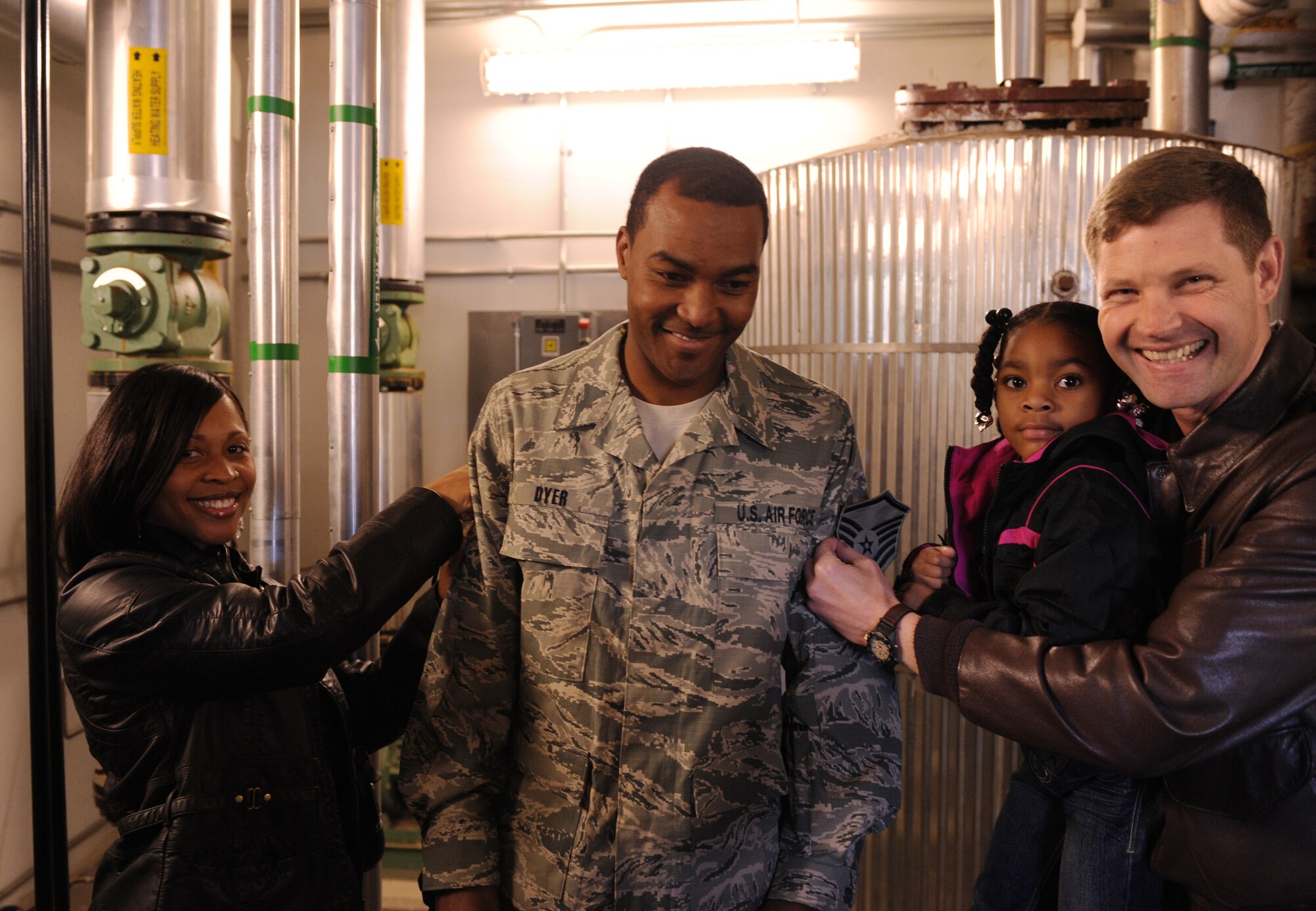 MOODY AIR FORCE BASE, Ga. -- Tech. Sgt. Alvin Dyer, 23rd Civil Engineering Squadron heating, ventilation and air conditioning NCO in-charge, stands while his wife, Tanquer, daughter, Cassidy, and Col. Gary Henderson, 23rd Wing commander, pin on his chevrons during his promotion to master sergeant here Dec. 29. Sergeant Dyer was promoted under the Stripes for Exceptional Performers program. (U.S. Air Force photo by Airman 1st Class Benjamin Wiseman)