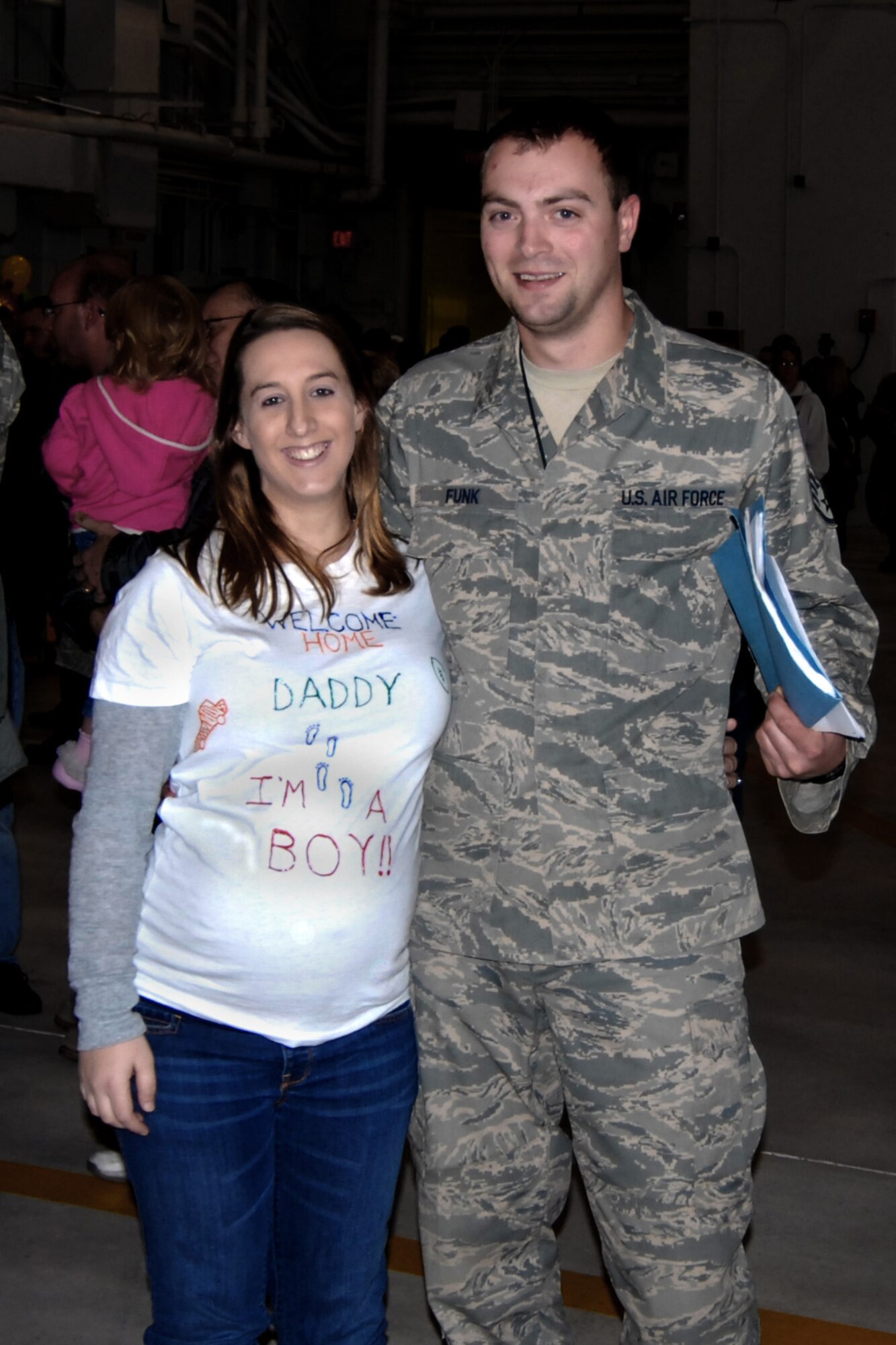 Amber Funk surprised her husband Staff Sgt. David Funk upon his return to 132nd Fighter Wing, Des Moines, Iowa, with a t-shirt announcement of the sex of their child. Staff Sgt. Funk was deployed to Joint Base Balad, Iraq as part of the 132nd's AEF in support of Operation Iraqi Freedom. (U.S. Air Force/Senior Master Sgt. Tim Day)(released)