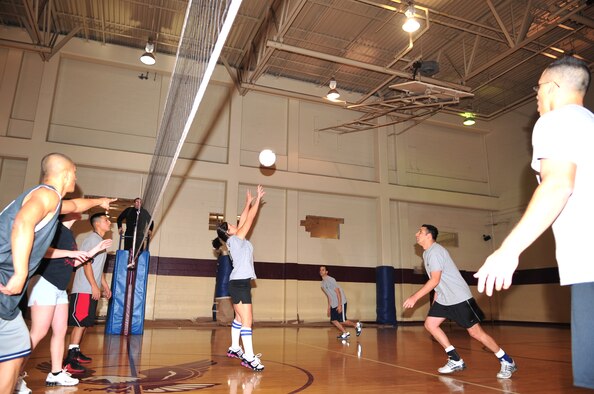 Lucy Lindstamer, 4th Civil Engineers Squadron, sets the ball for one of her team mates to spike during an intramural volleyball championship game on Seymour Johnson Air Force Base, N.C., Dec. 21, 2009. Each team had a win on the board going into the final game where the 4th CES were victorious. (U.S. Air Force photo/Airman 1st Class Rae Perry)