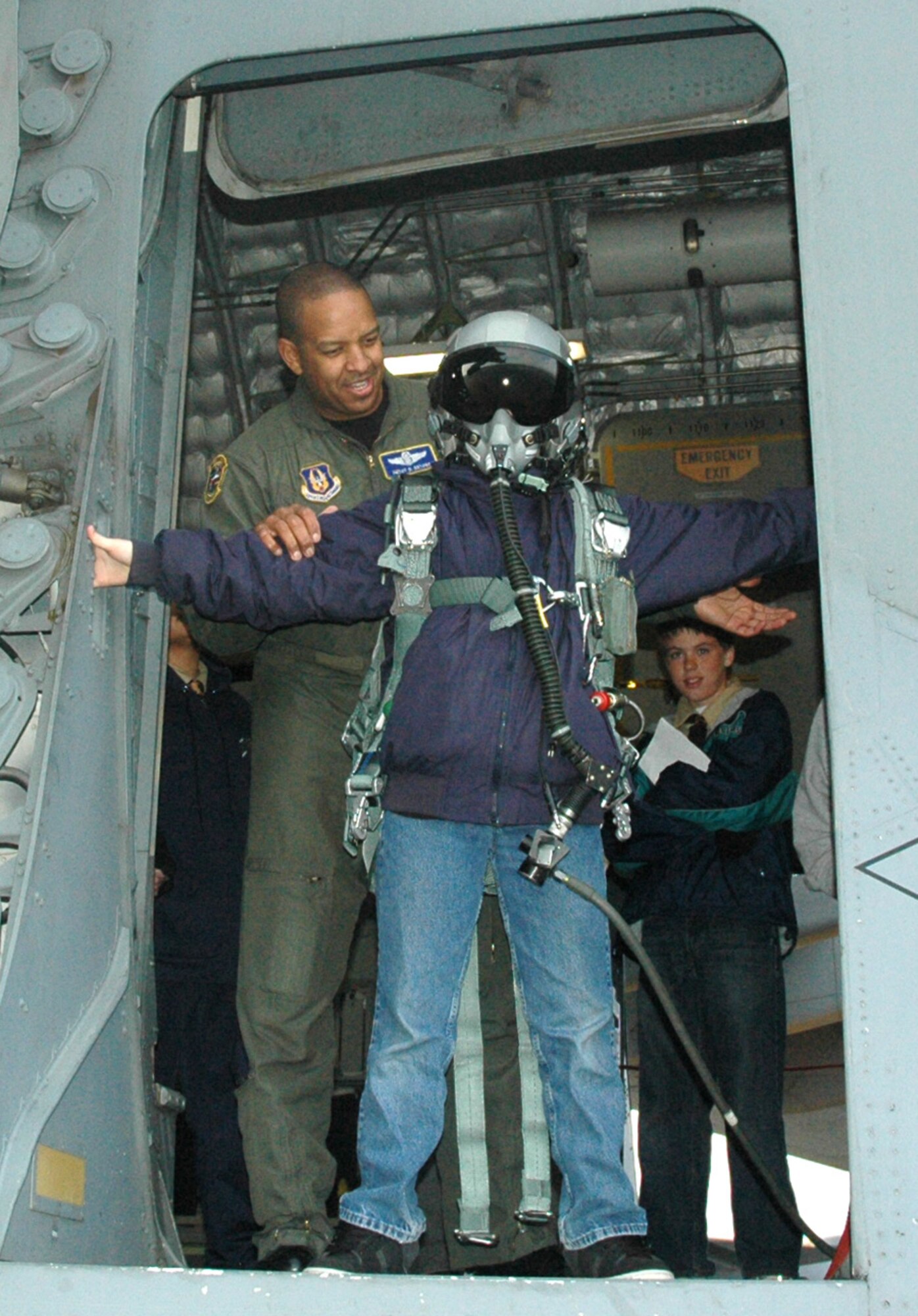 MCCHORD AIR FORCE BASE, Wash.- Senior Master Sgt. Derek Bryant, left, loadmaster with the 728th Airlift Squadron here, dons a Boy Scout in a parachute, helmet, and an oxygen mask on a C-17 Globemaster static display here in order to give the visiting Boy Scouts the experience of an airman getting ready to jump out of a C-17. Boy Scout troops 249 out of Richland, Wash. and 594, Maple Valley, Wash. were taken onto the aircraft so they could earn their Aviation Merit badges. (U.S. Air Force photo/Master Sgt. Jake Chappelle)