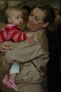 Tech. Sgt. Erin Manley adoringly holds eight month old Margeaux Pearson prior to departure for a four month deployment Dec. 28 at the passenger terminal here. The 14th Airlift Squadron is deploying to the Middle East in support of Operation Iraqi Freedom and Operation Enduring Freedom. Tech. Sergeant Manley is a loadmaster assigned to the 14th Airlift Squadron and Margeaux is a friend's daughter. (U.S. Air Force photo/Airman 1st Class Lauren Main)