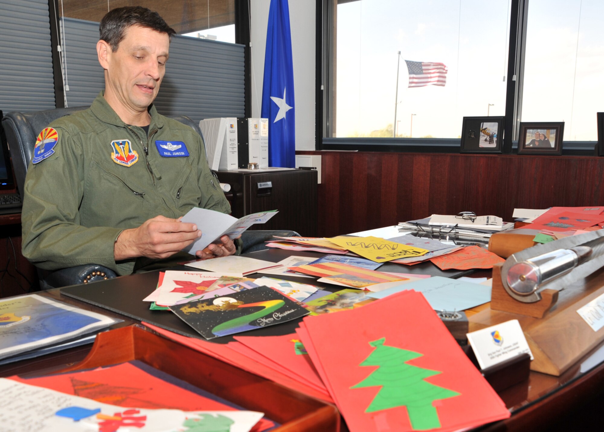Davis-Monthan Air Force Base, Ariz -- Brig. Gen. Paul Johnson, 355th Fighter Wing commander, reads holiday card made by local students here, Dec. 22. Students decorated more than 2,000 cards for D-M and deployed airmen hoping to lift their spirits during the holiday season. (U.S.Air Force photo/Master Sgt. Heather Cabral)