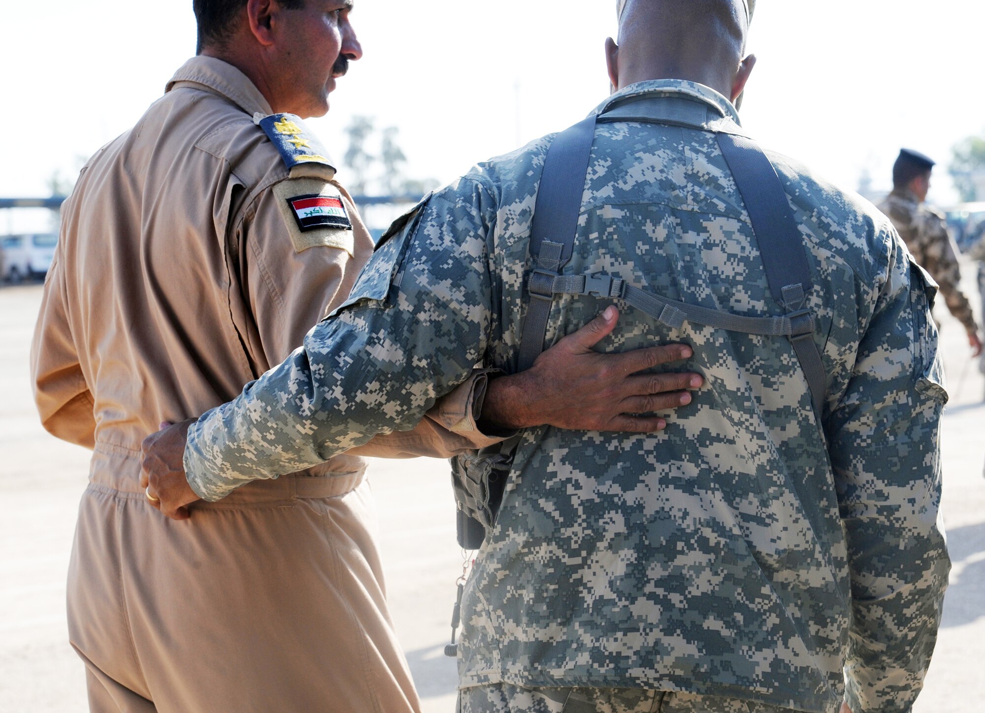 A U.S. Army servicemember embraces an Iraqi servicemember after a basic military training Top Off course graduation ceremony at the Iraqi Air Force Training School Dec. 28, 2009 at Camp Taji, Iraq. The U.S. Air Force played an advisory role in this completely Iraqi-led air force training course. (U.S. Air Force photo/Master Sgt. Trish Bunting)