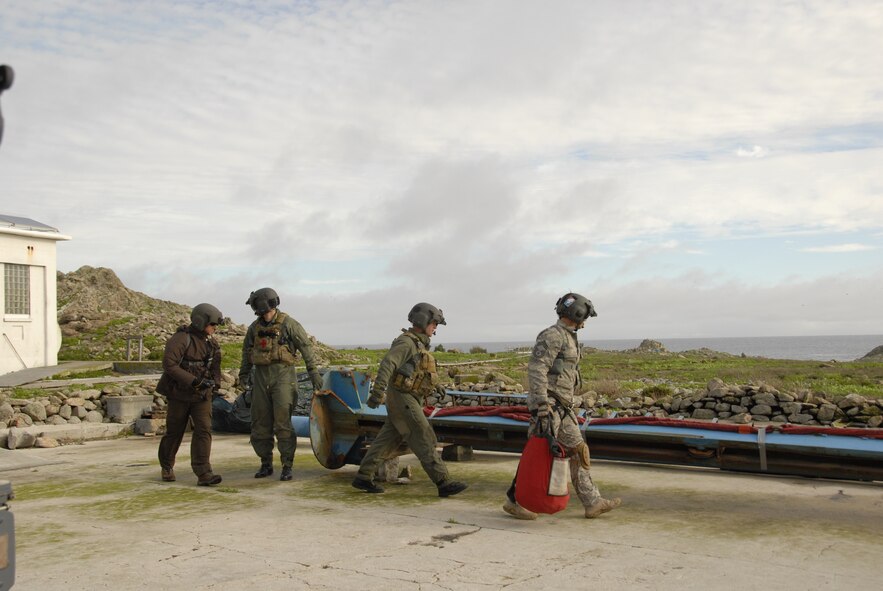 An HH-60G Pave Hawk crew from the 129th Rescue Wing prepares to attach a cargo sling to pieces of a Farallon National Wildlife Refuges' boat crane Dec 21. The unit supported the U.S. Fish and Wildlife Service by transporting crane pieces to nearby Stinson Beach. (Air National Guard  photo by Airman 1st Class Jessica Green)