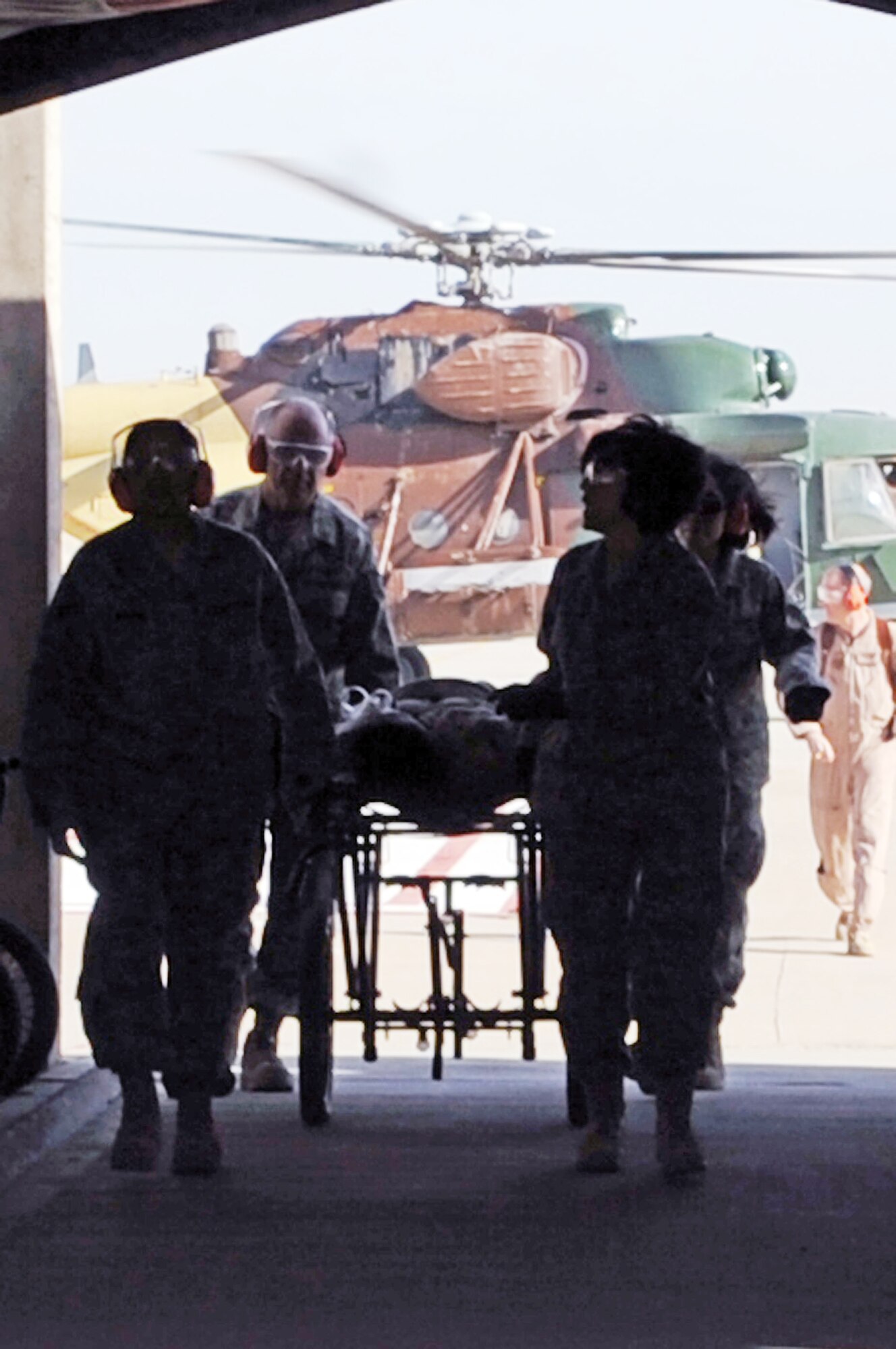 Airmen from the 332nd Expeditionary Medical Group transport a mock patient from an Iraqi helicopter during medical evacuation training for the Iraqi air force Dec. 21, 2009, at Joint Base Balad, Iraq. The purpose of the training is to help Ministry of Defense officials strengthen their health care system for Iraqi troops. (U.S. Air Force photo/Senior Airman Brittany Bateman)
