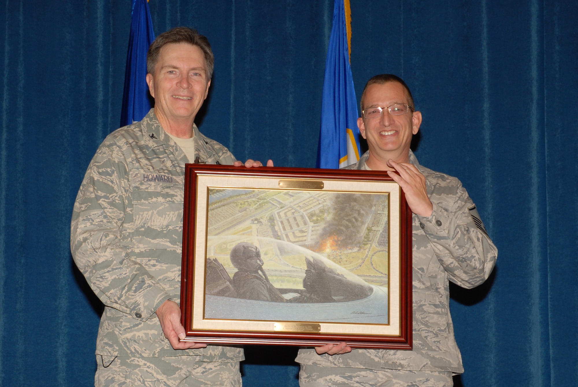 McGHEE TYSON AIR NATIONAL GUARD BASE, Tenn. -- Master Sgt. Andrew D. Traugot, right, an instructional systems analyst for the enlisted professional military education branch, receives a heritage painting from Col. Richard B. Howard, commander, upon his departure from assignment at The I.G. Brown Air National Guard Training and Education Center here, Dec. 18, 2009.  (U.S. Air Force photograph by Master Sgt. Mavi Smith/Released)
