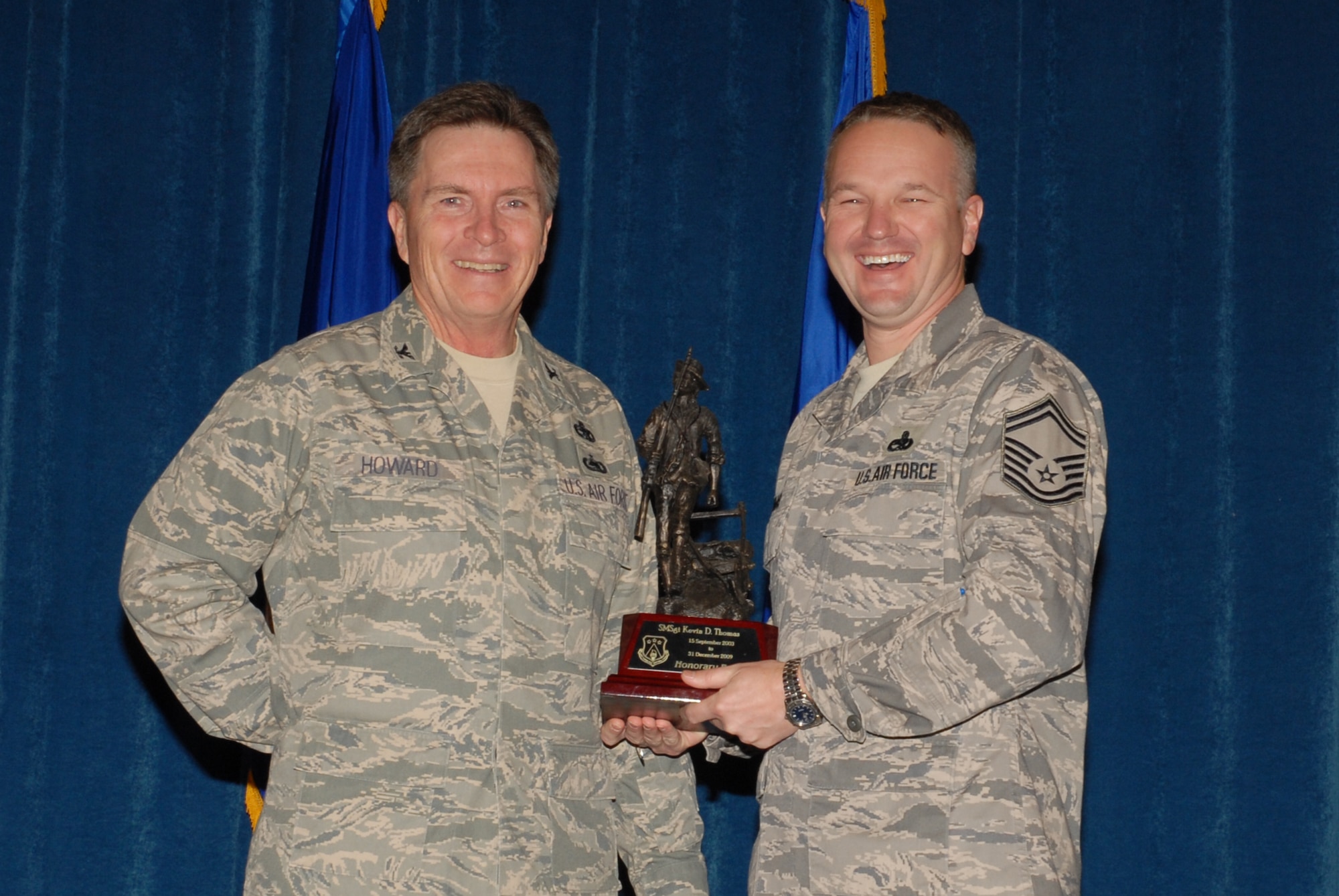 McGHEE TYSON AIR NATIONAL GUARD BASE, Tenn. -- Senior Master Sgt. Kevin Thomas, right, the director of resources for enlisted professional military education, receives the honorary faculty award from Col. Richard B. Howard, commander, upon his departure from assignment at The I.G. Brown Air National Guard Training and Education Center here, Dec. 18, 2009.  (U.S. Air Force photograph by Master Sgt. Mavi Smith/Released)