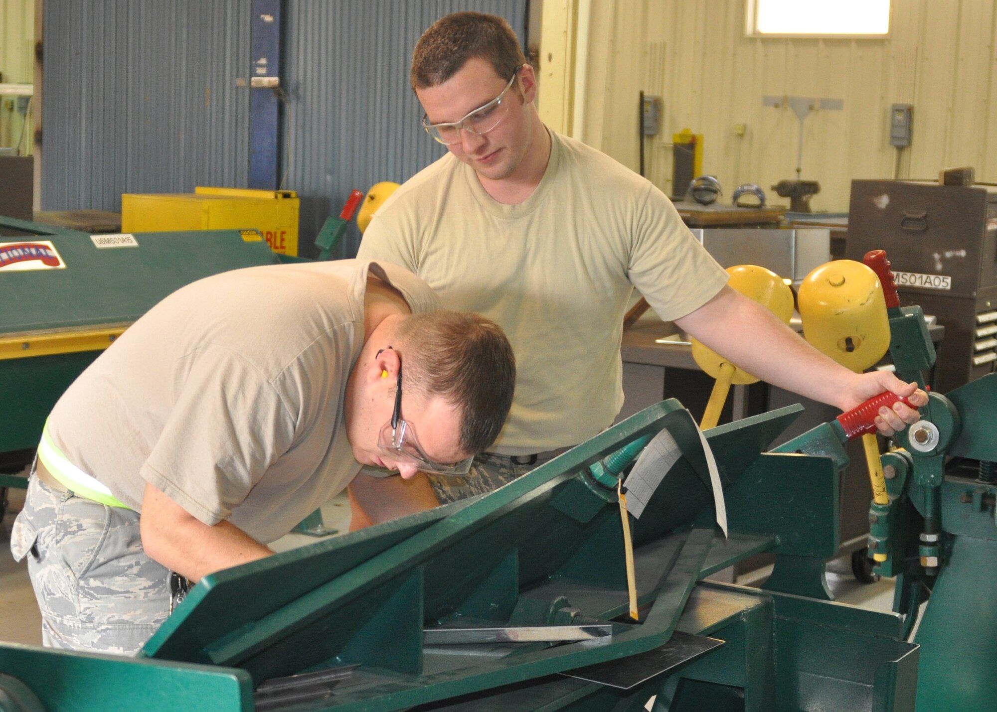 Airman 1st Classes Alex Baker and David Shellgren, both aircraft structural maintenance technicians working in the 917th Maintenance Squadron Fabrications Shop (MXMFS)  at Barksdale Air Force Base, La., team up to bend steel for one of their various projects in the Fabrications Shop December 28, 2009. Airman Baker looks on, holding a lever steady while Airman Shellgren rechecks measurements on the steel. Both Airman Baker and Shellgren are active duty Airmen from the 2nd Bomb Wing here, who have been in the 917th Fabrications Shop since July 2009 in support of Total Force Integration. (U.S. Air Force Photo/ Senior Airman Crystal Marie Jordan)