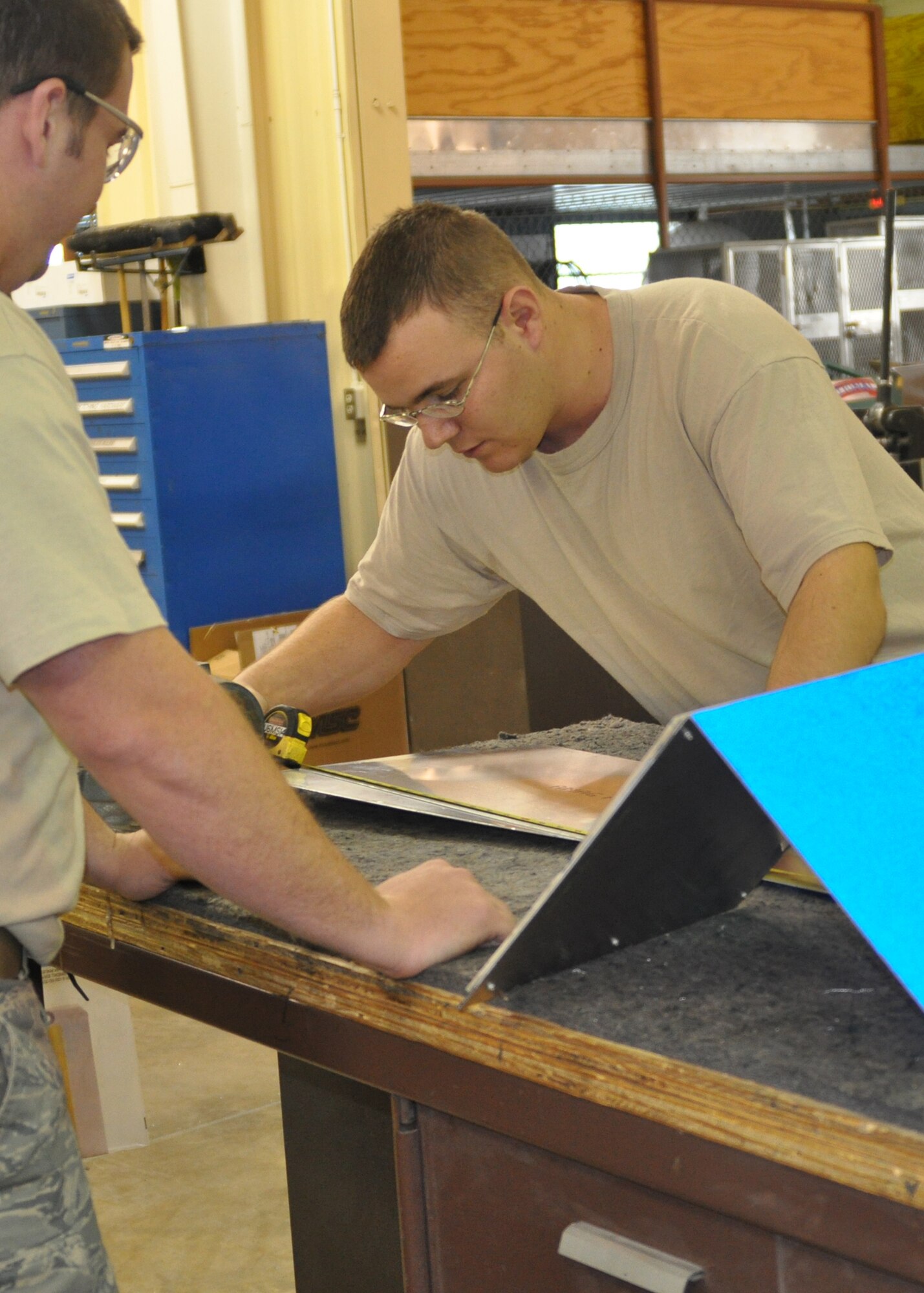 Airman 1st Classes Alex Baker and David Shellgren, both aircraft structural maintenance technicians working in the 917th Maintenance Squadron Fabrications Shop (MXMFS) at Barksdale Air Force Base, La., measure out scrap metal being used for one of their projects in the shop December 28, 2009. Airman Shellgren rechecks measurements as Airmen baker looks on, in order to assure that the project will be a success. In the 917th Fabrications Shop, projects and assigned duties are usually so big that the Airmen will often work as a group to complete these tasks.   (U.S. Air Force Photo/ Senior Airman Crystal Marie Jordan)