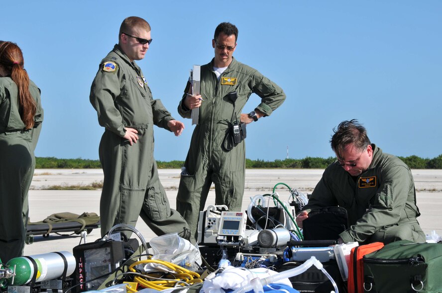 Capt. Adam Hohman (left) of the 934th Aeromedical Evacuation Squadron describes the proper use of medical support equipment to Florida Advanced Surgical and Transport Team members Dr. Joe Scott (center) and Dr. Michael Ksychi. 