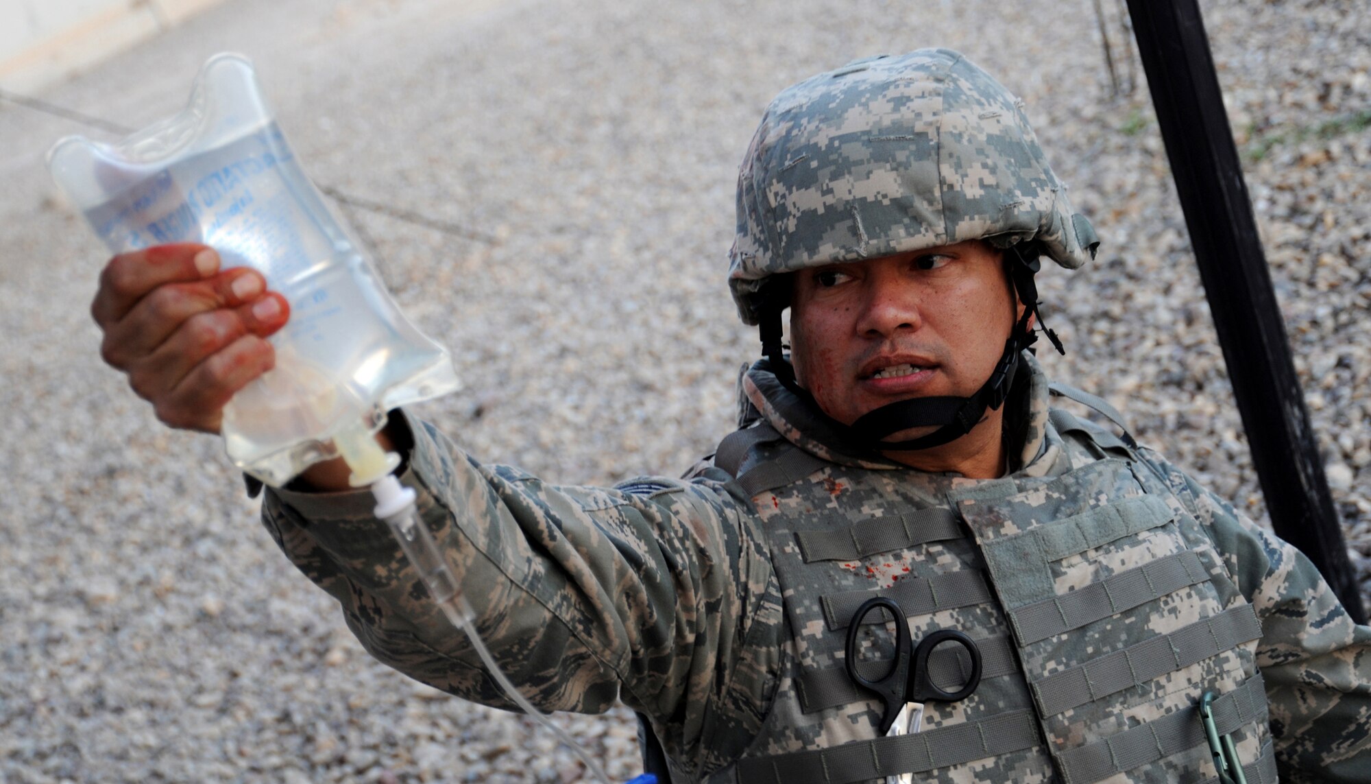 JOINT BASE BALAD, Iraq -- Tech. Sgt. Rafael Martinez of the 332nd Expeditionary Communications Squadron raises a saline bag as he provides field care for a mock patient during a combat lifesaver course Dec. 11, 2009. The 1st Medical Brigade instructs three to four classes a month, which are open to all military branches, DOD civilians and even contractors. (U.S. Air Force photo/Senior Airman Christopher Hubenthal)
