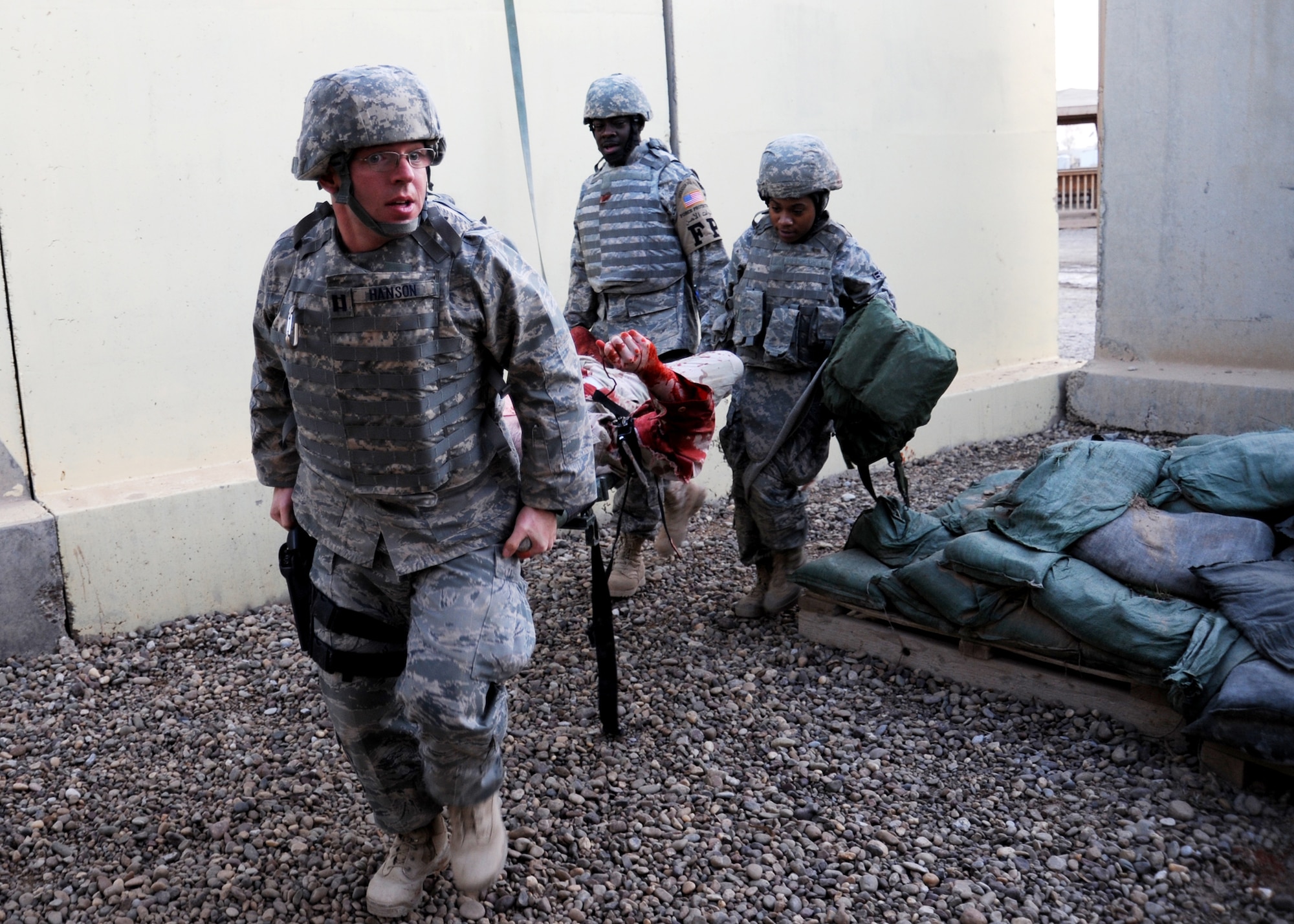 JOINT BASE BALAD, Iraq -- Capt. Tim Hanson of the 727th Expeditionary Air Control Squadron leads Staff Sgt. Robert Charles, 332nd Expeditionary Civil Engineer Squadron force protection escort, and Airman 1st Class Acquah Hill of the 532nd Expeditionary Security Forces Squadron, as they transport a mock casualty during a combat lifesaver course Dec. 11, 2009. The combat lifesaver course is a three-day accelerated course, qualifying servicemembers on tactical field care. (U.S. Air Force photo/Senior Airman Christopher Hubenthal)